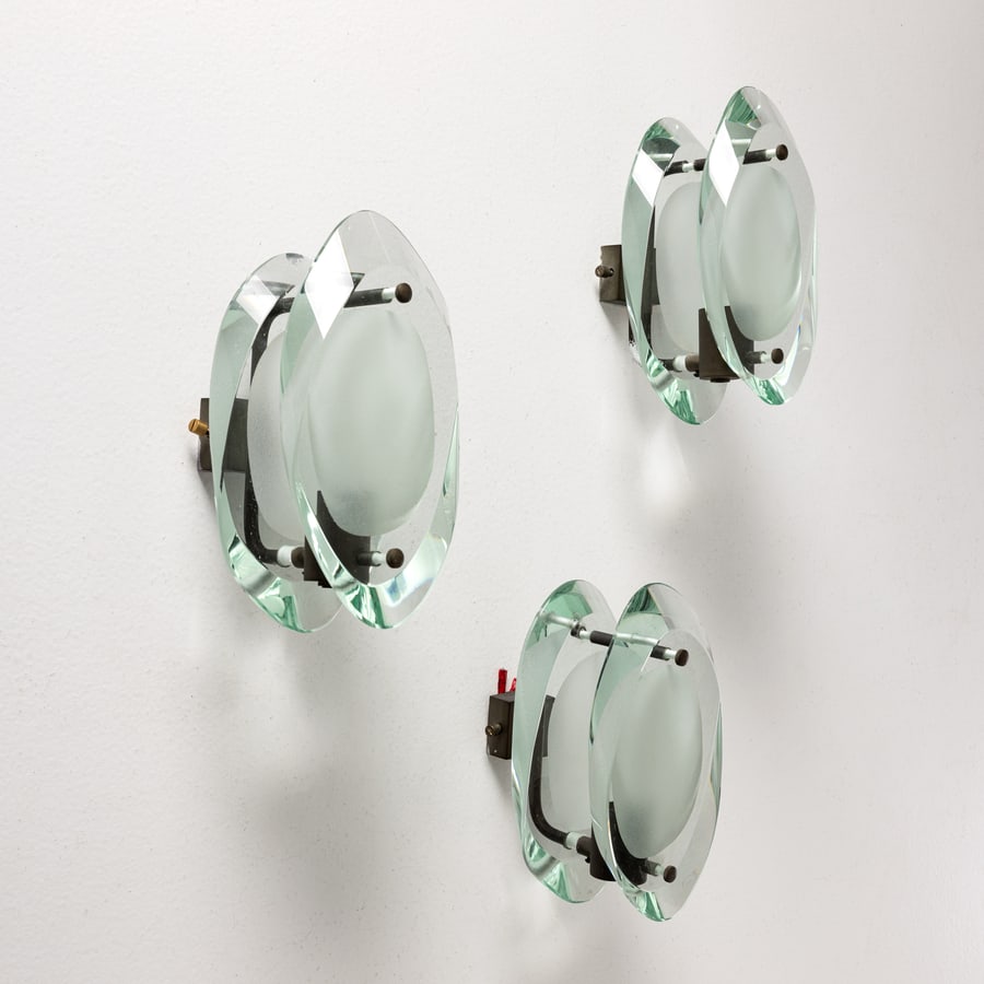 MAX INGRAND: Tre lampade da parete. Ottone nichelato, cristallo di forte spessore molato, scavato e parzialmente sabbiato. Produzione Fontana Arte, 1960 ca. cm 22x13x15 ca. THREE WALL LAMPS BY M. INGRAND Cfr.:
