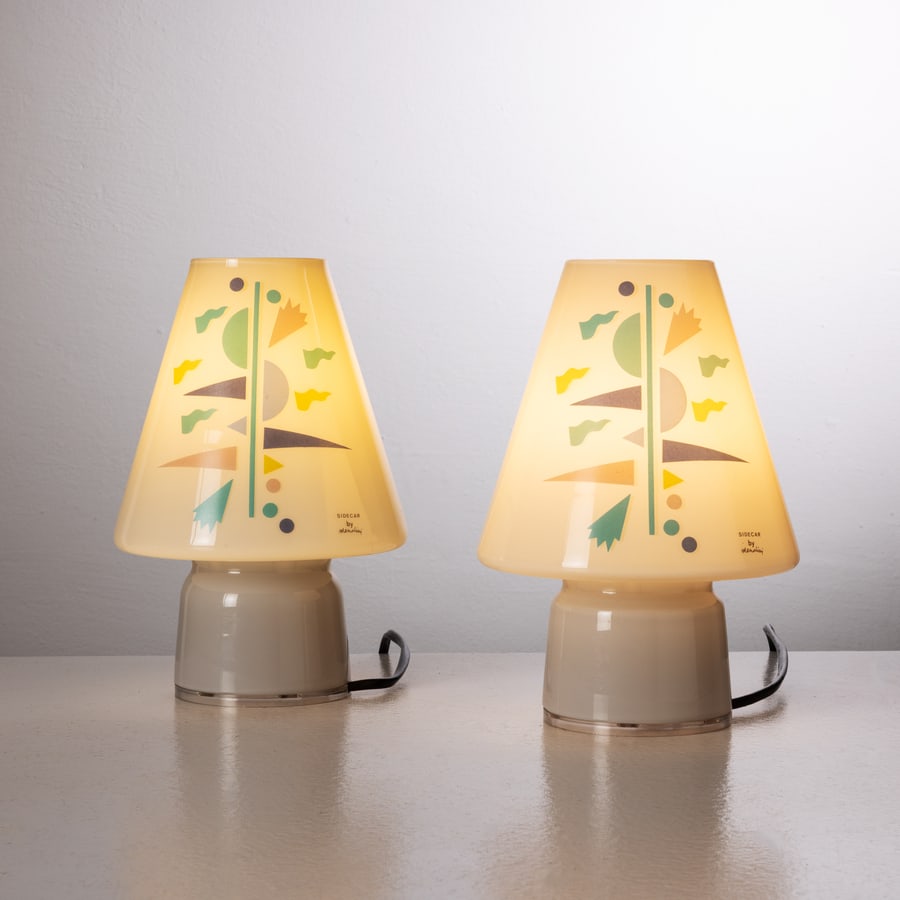 ALESSANDRO MENDINI: Coppia di lampade da comodino mod. Bibi. Vetro serigrafato. Produzione Artemide 1993. Etichetta della manifattura cm 22,5x15x15 A PAIR OF TABLE LAMPS BY A. MENDINI Buone condizioni generali. Piccole r