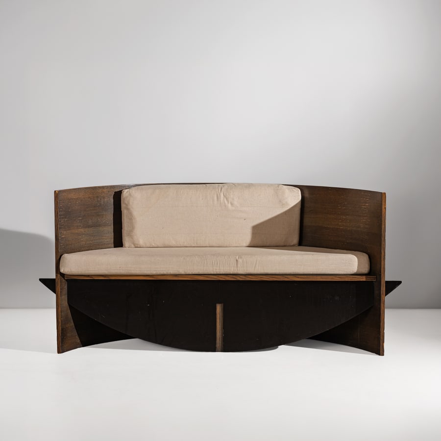 CHRISTIAN DE PORTZAMPARC (NEL GUSTO DI ): Panca per una residenza privata, Nizza. Multistrato curvato impiallacciato rovere tinto all'anilina ed ebanizzato, tessuto imbottito. Francia seconda metà anni '80. cm 81x182x48 A BENCH IN THE
