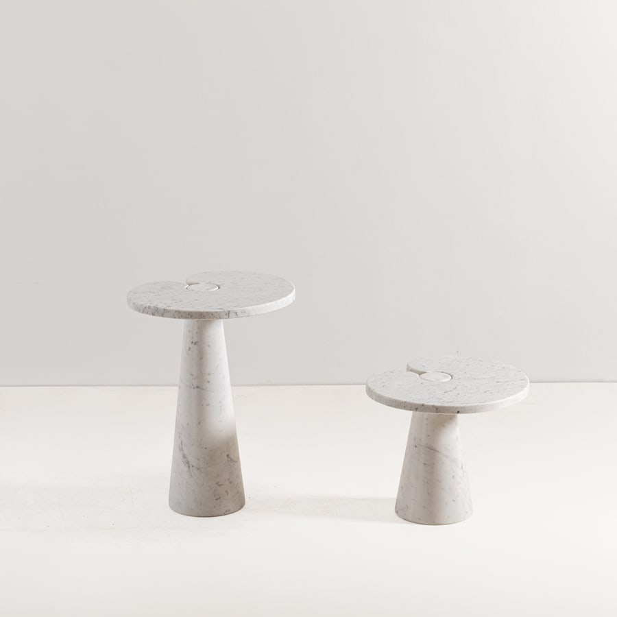 ANGELO MANGIAROTTI: Due guéridon della serie Eros. Marmo bianco di Carrara tornito e lavorato. Italia XX secolo. cm 45x55x44,5; cm 72x55x44,5- TWO LOW TABLES BY A. MANGIAROTTI Casa Amica, 11 maggio 1971, pp. 24-24;