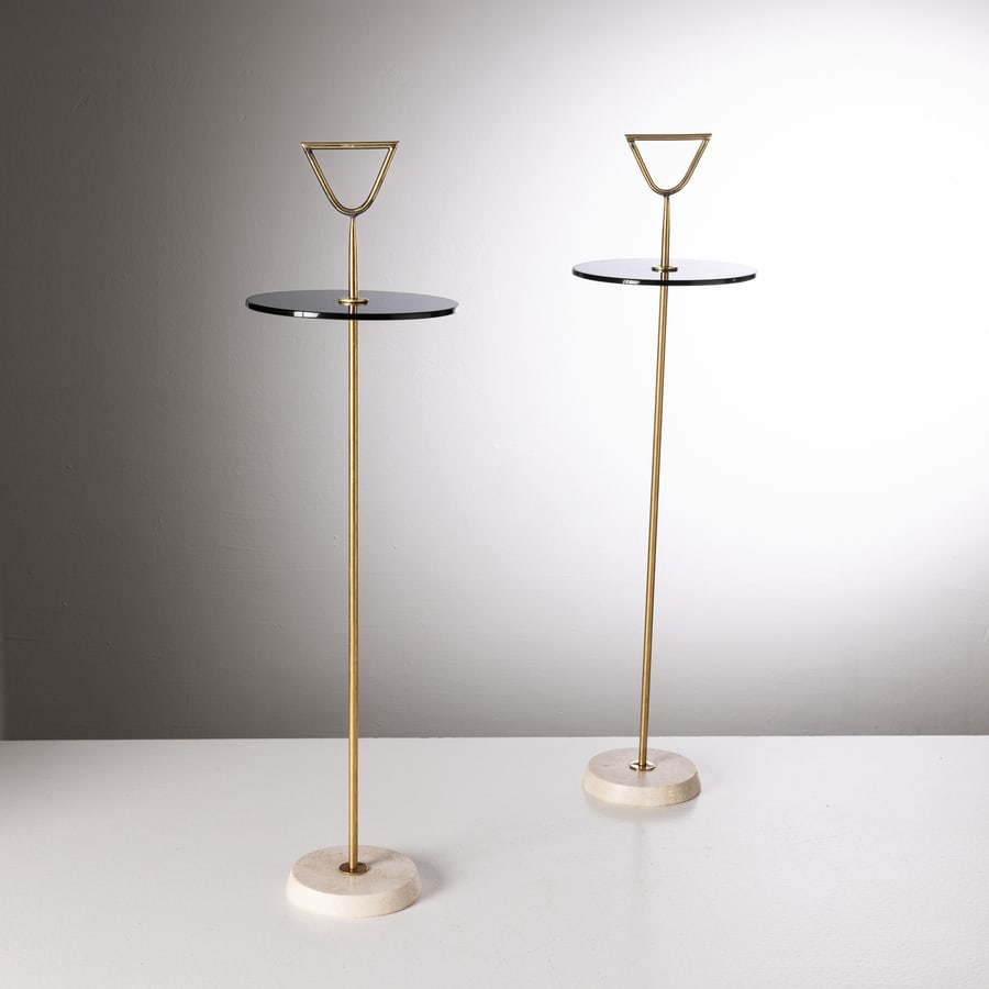 MANIFATTURA ITALIANA: Coppia di tavolini servimuti. Travertino, ottone, cristallo molato e colorato. Italia, anni '80. cm 66x18x18 A PAIR OF ITALIAN VALETS Buone condizioni generali. Piccole righe, leggeri graffi, normali