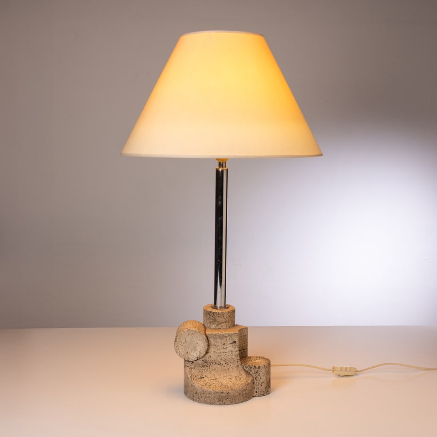MANIFATTURA ITALIANA: Lampada da tavolo. Travertino, metallo cromato, tessuto. Italia anni '70. altezza con paralume cm 82; base cm 26x18,5 ca. AN ITALIAN TABLE LAMP Buone condizioni. Righe, segni di usura, ossidazione.