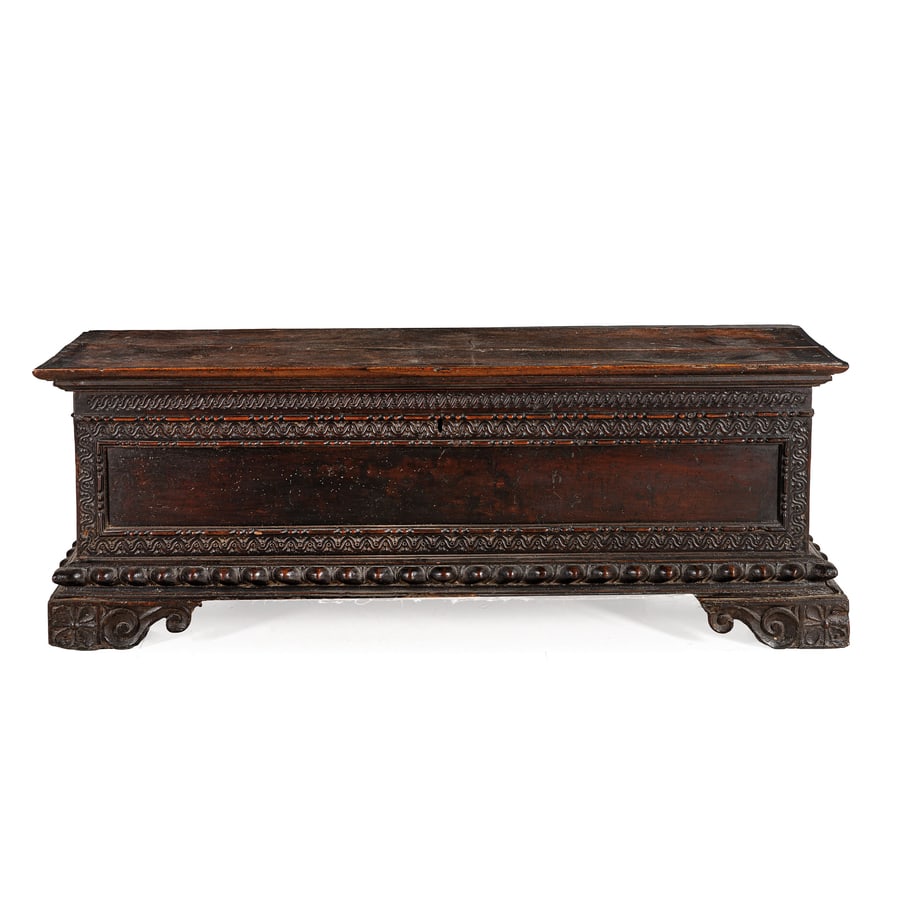 CASSONE IN LEGNO DI NOCE INTAGLIATO E PATINATO, XVII: SECOLO cornici baccellate e piedi a mensola con grandi volute a ricciolo; difetti, poche tracce di tarlo, fenditura nel piano, restauri, parti di cornice da fissare, la chiave mancante Cm 66X185X59 A 