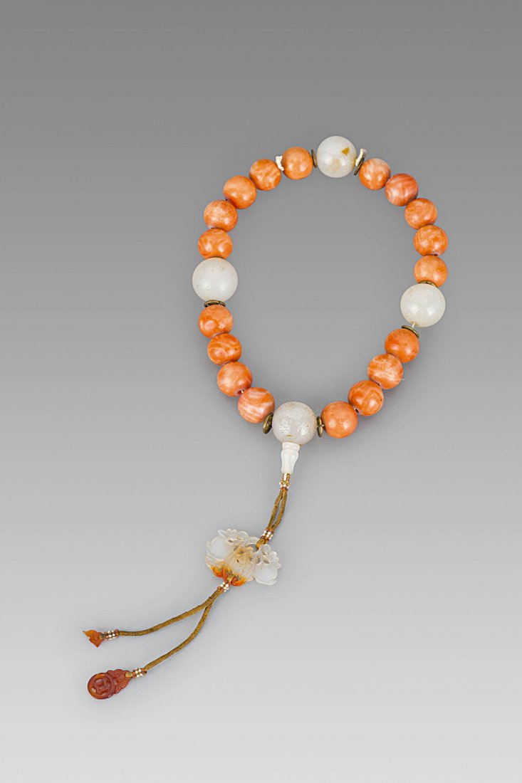 A BUDDHIST ROSARY BRACELET, CHINA, LATE QING DYNASTY: A BUDDHIST ROSARY BRACELET, CHINA, LATE QING DYNASTY - In semiprecious stone and jade, with a bat pendant. A cash is missing in the pendant.