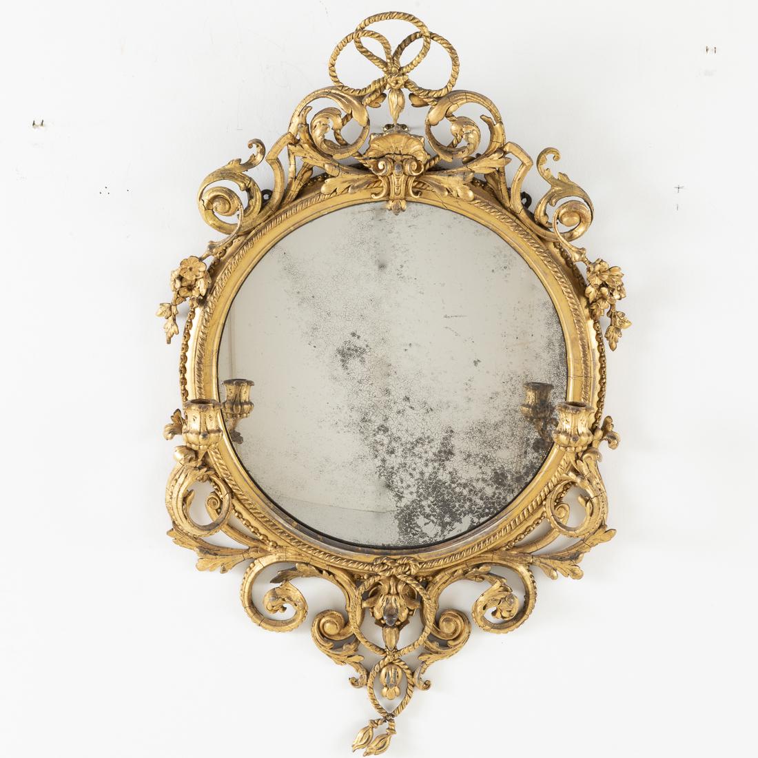 Continental Giltwood Convex Girandole Mirror, 19th C: Property of a Private Collection, Savannah, GA issuing two candle arms with twisted rope border and scrolled crest and apron. H. 37 in. x W. 21 in.