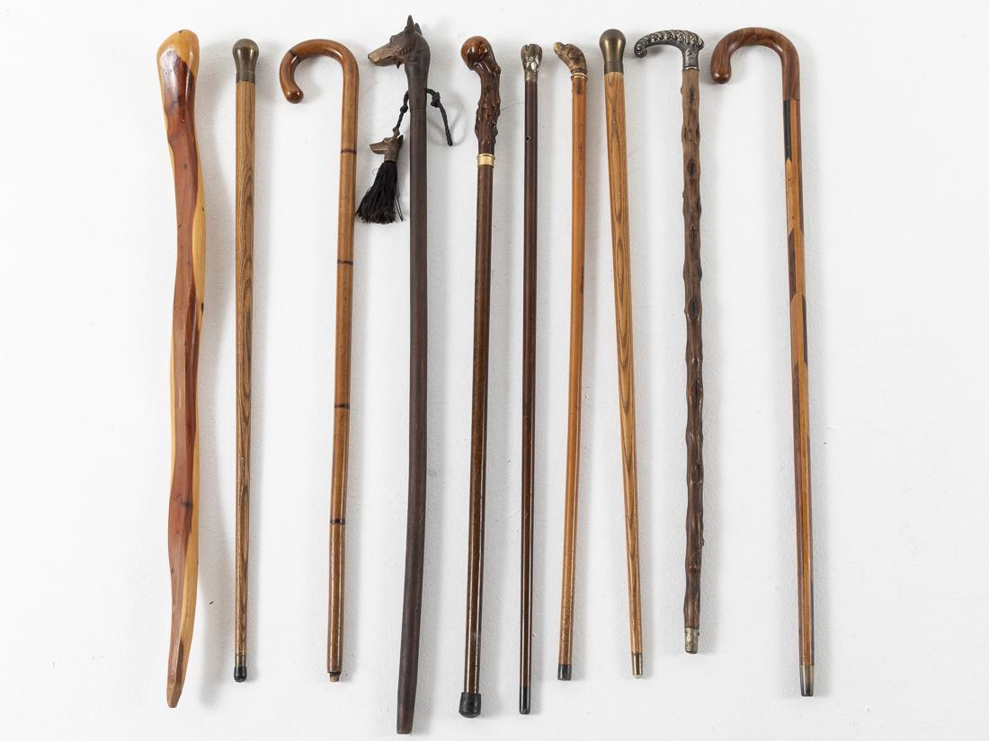 10 Walking Sticks: Property from a South Carolina Collector comprising a carved wood walking stick (with wear to bottom and old marks and scratches), a wood inlaid cane with shepard crook handle and horn tip (old marks 
