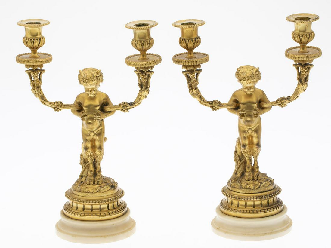 Pair of French Gilt-Bronze Candelabra, 19th C: Pair of French Gilt-Bronze Two-Light Candelabra, 19th C., the cherub satyrs with branch form candle arms on a round stone base. MEASURMENTS: Height: overall 13 1/4 in. x Width: 8 3/4 in. x Depth: 5 in