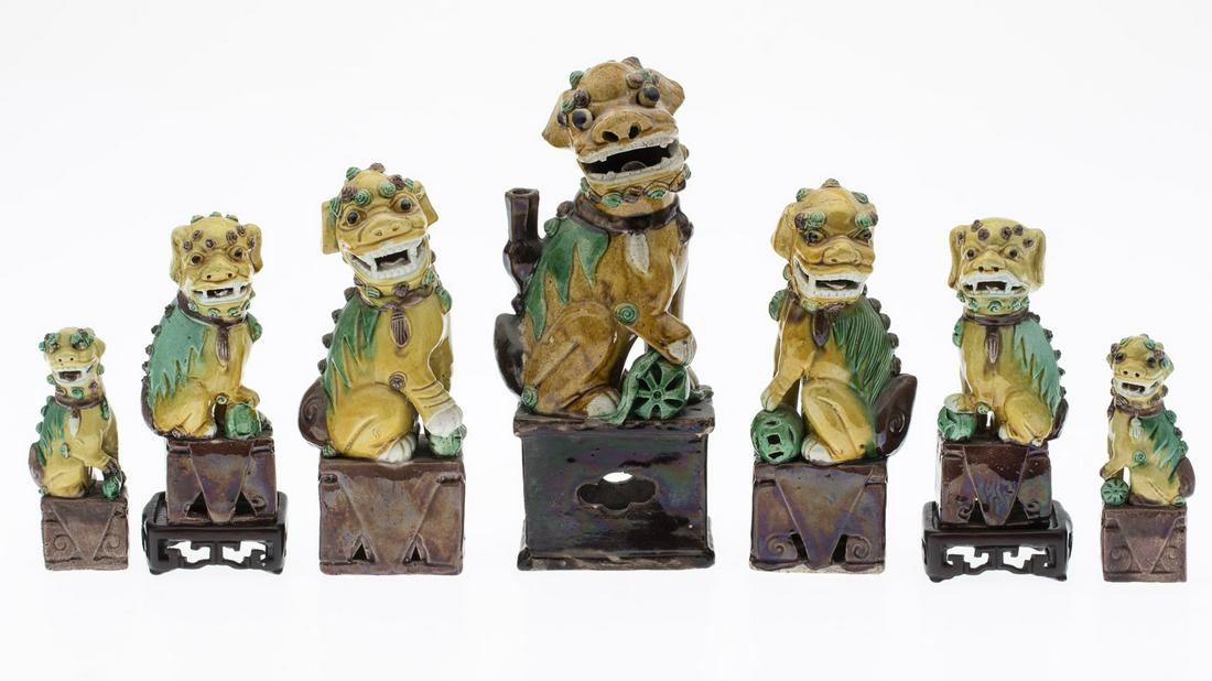 7 Yellow and Green Ceramic Fu Dogs: 7 Yellow and Green Ceramic Fu Dogs, comprising a pair of small foo dogs (marked 'China' on bases), a pair of medium foo dogs, two similar larger foo dogs (with associated wood stand), and one large fo