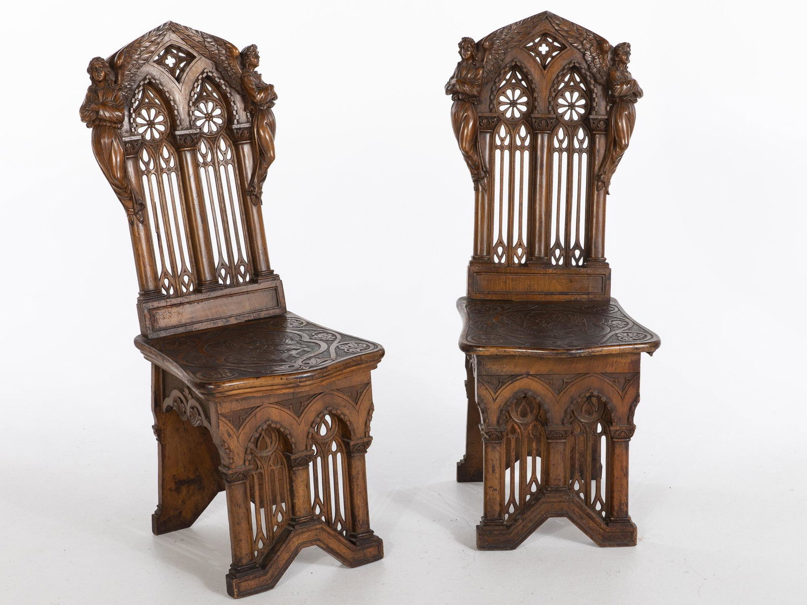 Pair of Renaissance Revival Walnut Side Chairs, 19th C: Pair of Renaissance Revival Walnut Side Chairs, 19th Century, each with architectural carved back carved with angels above a carved plank seat raised on a similarly carved architectural base. MEASURME