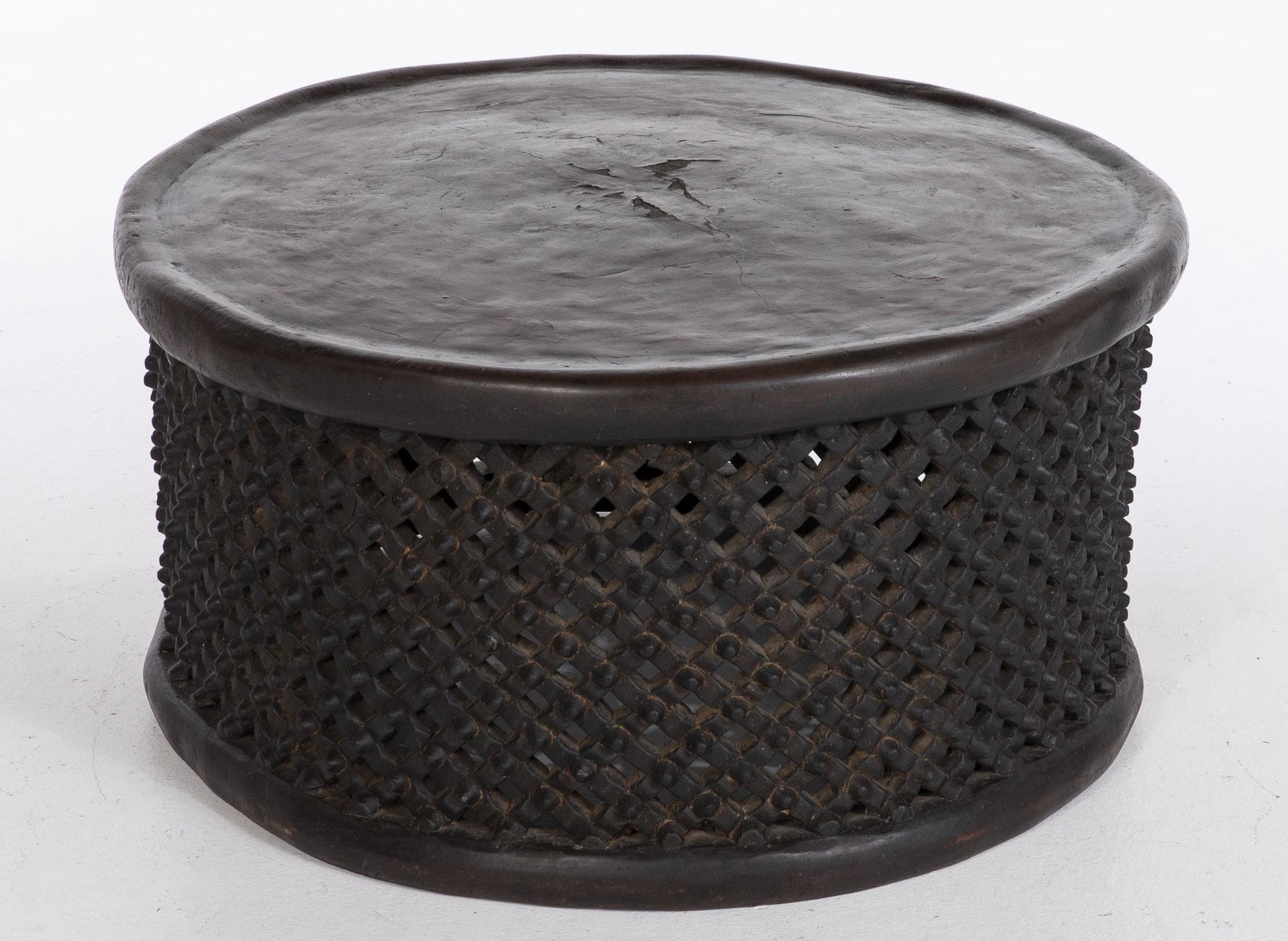 African Carved Wood Bamileke Low Table: African Carved Wood Bamileke Low Table, the circular top above lattice carved sides. MEASURMENTS: Height: 18 1/4 in. x Width: 35 in.