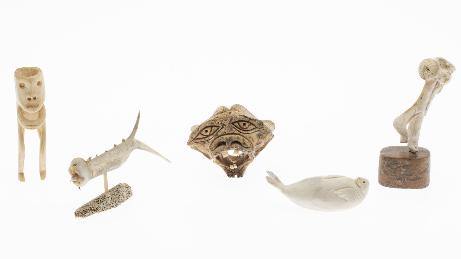 5 Inuit Bone and Antler Carvings: 5 Inuit Bone and Antler Carvings, comprising a seal, a standing figure on a stone base, another standing figure, a head (illegibly signed on base), and a fish. MEASURMENTS: Height: of head 2 3/4 in. x