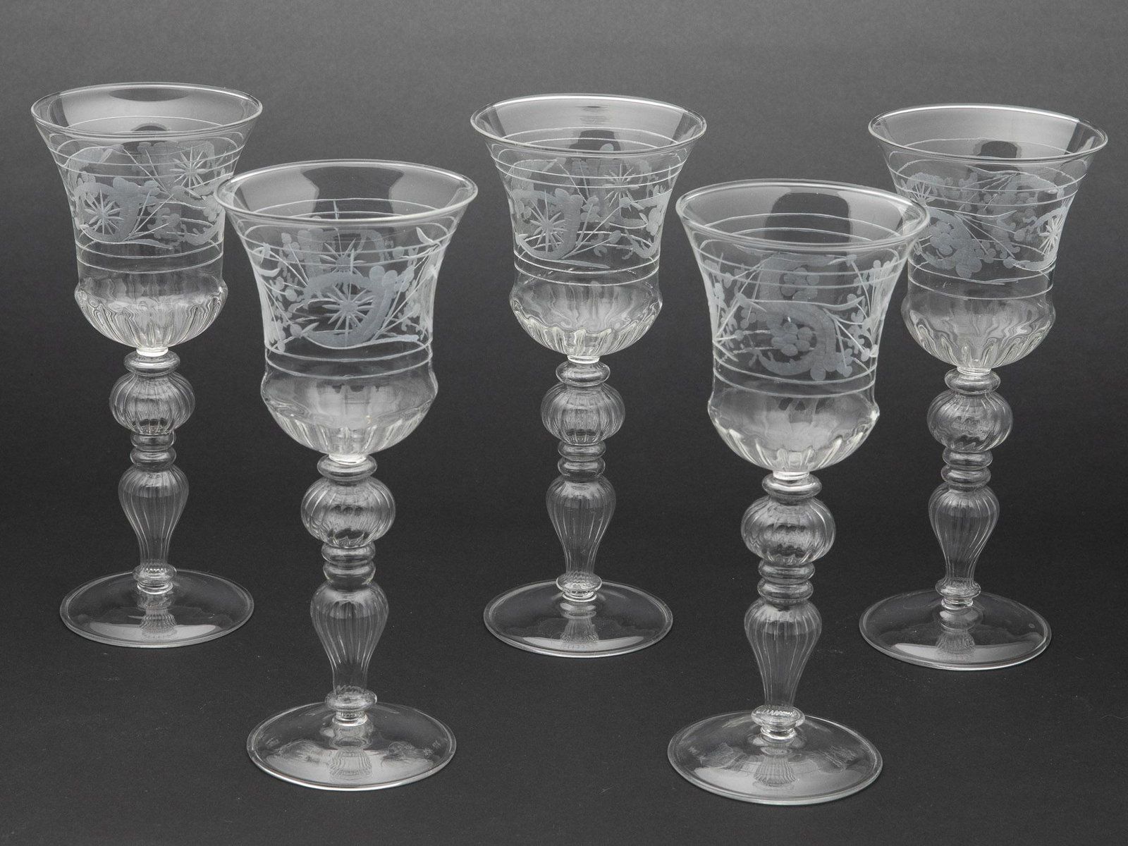 5 Venetian Wine Glasses: 5 Venetian Wine Glasses, blown glass Venetian wine glasses with etched decoration. MEASURMENTS: Height: 8 1/2 in. x Width: 3 1/2 in.