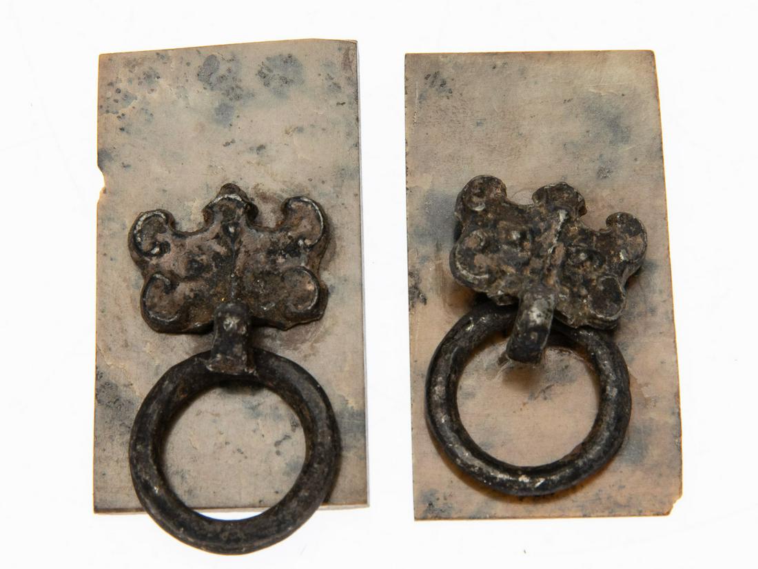 Pair of Han Dynasty Pulls: Property of a Florida Collector Description: Pair of Han Dynasty Pulls, rectangular stone backings loosely mounted with mask-form metal loop pulls, in a fitted box. Measurements: