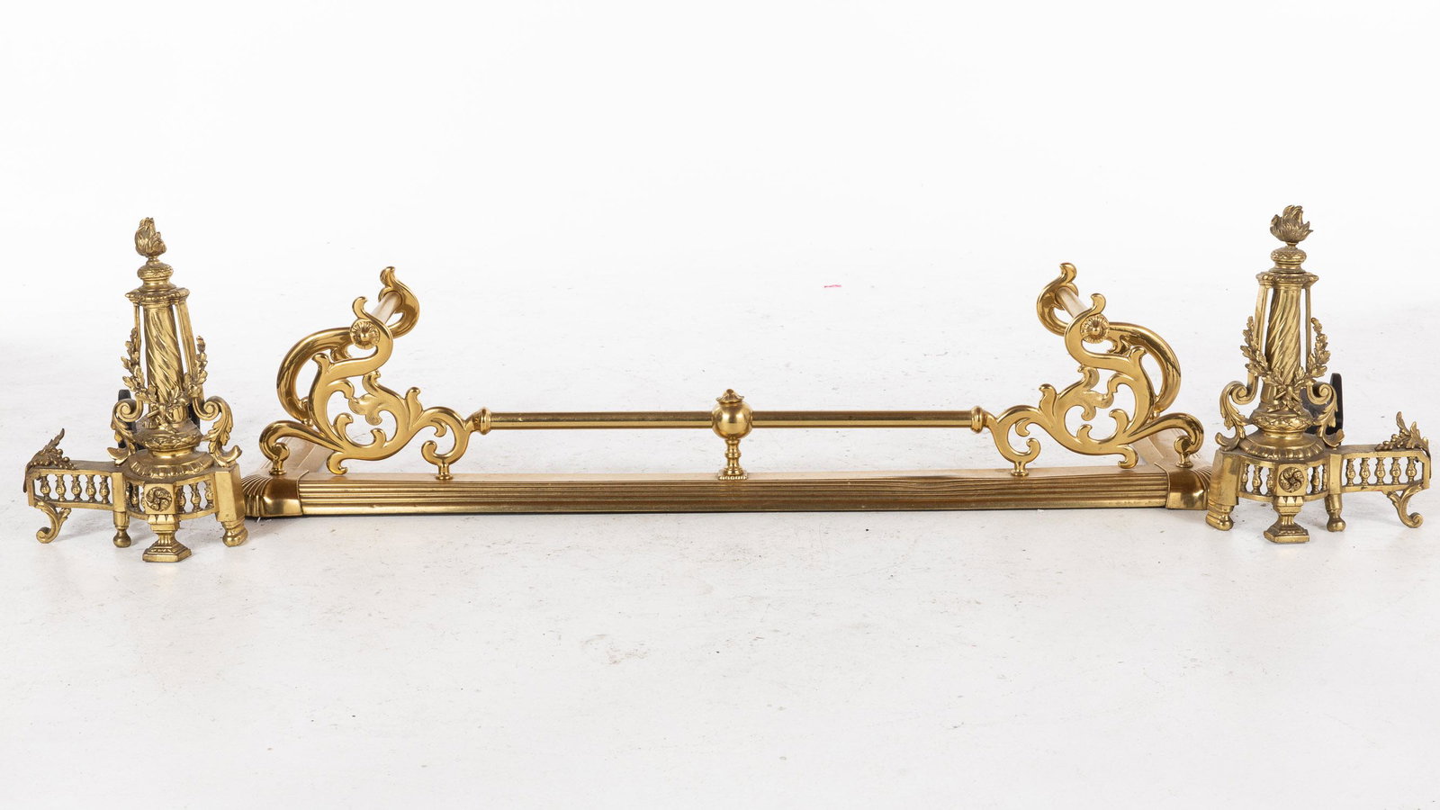 Pair of Louis XVI Style Chenets and a Fire Fender: Property from a Private Collection, Savannah, GA Description: Pair of Louis XVI Style Chenets and a Fire Fender, the chenets of columnar form with flame finials, together with a fender with scroll