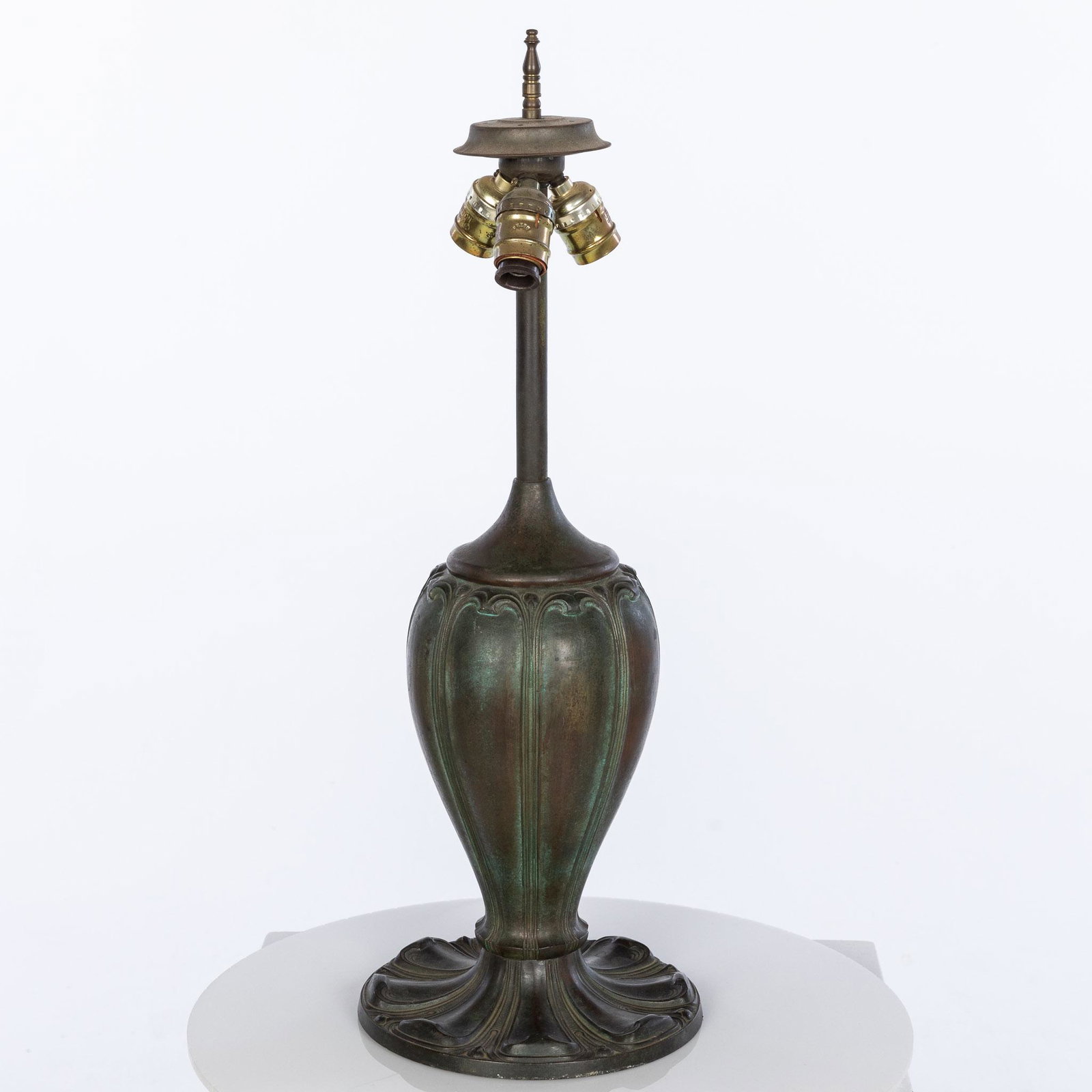 Art Nouveau Bronze Lamp Base: Property from the Collection of John and Virginia Duncan, Savannah, GA Description: Art Nouveau Bronze Lamp Base, the sockets marked Leviton, with reeded tapering body and circular base.