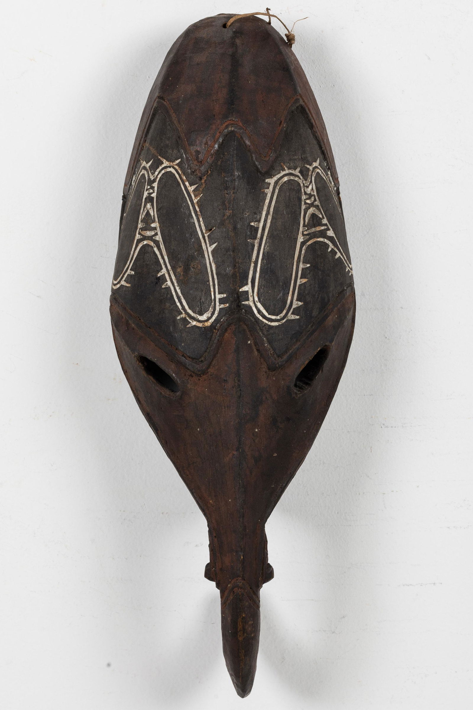 Large African Mask with Hook Nose: Property from the Collection of John and Virginia Duncan, Savannah, GA Description: Large African Mask with Hook Nose, carved wood and painted black mask with carved out eyes and elephant tusk nos