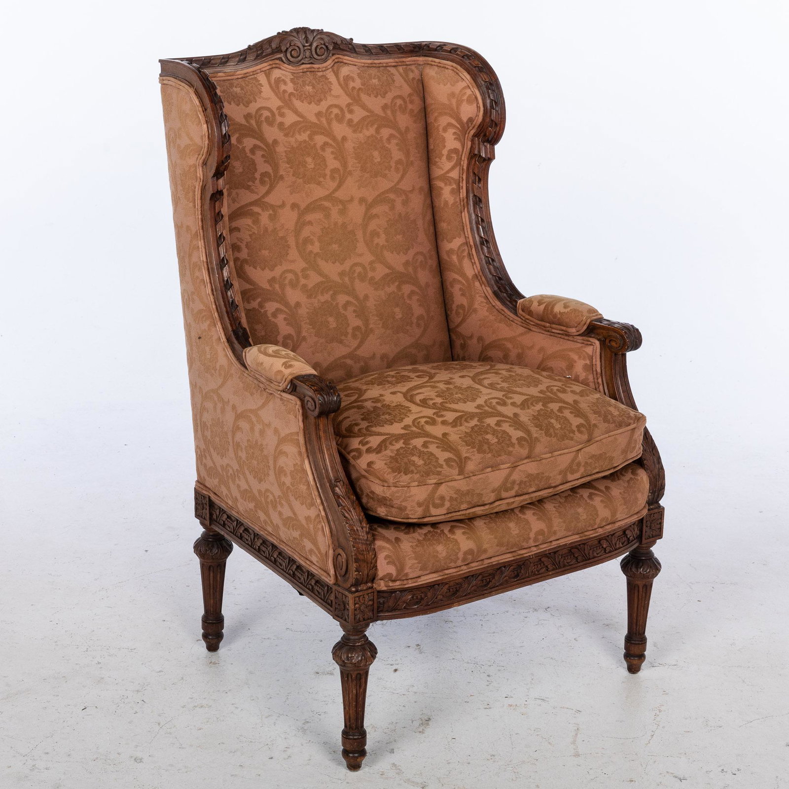Louis XVI Style Wing Chair: Property from a Private Collection, Savannah, GA Description: Louis XVI Style Wing Chair, with ribbon and leaf carved edges and loose fitted cushion, raised on fluted legs. Measurements: