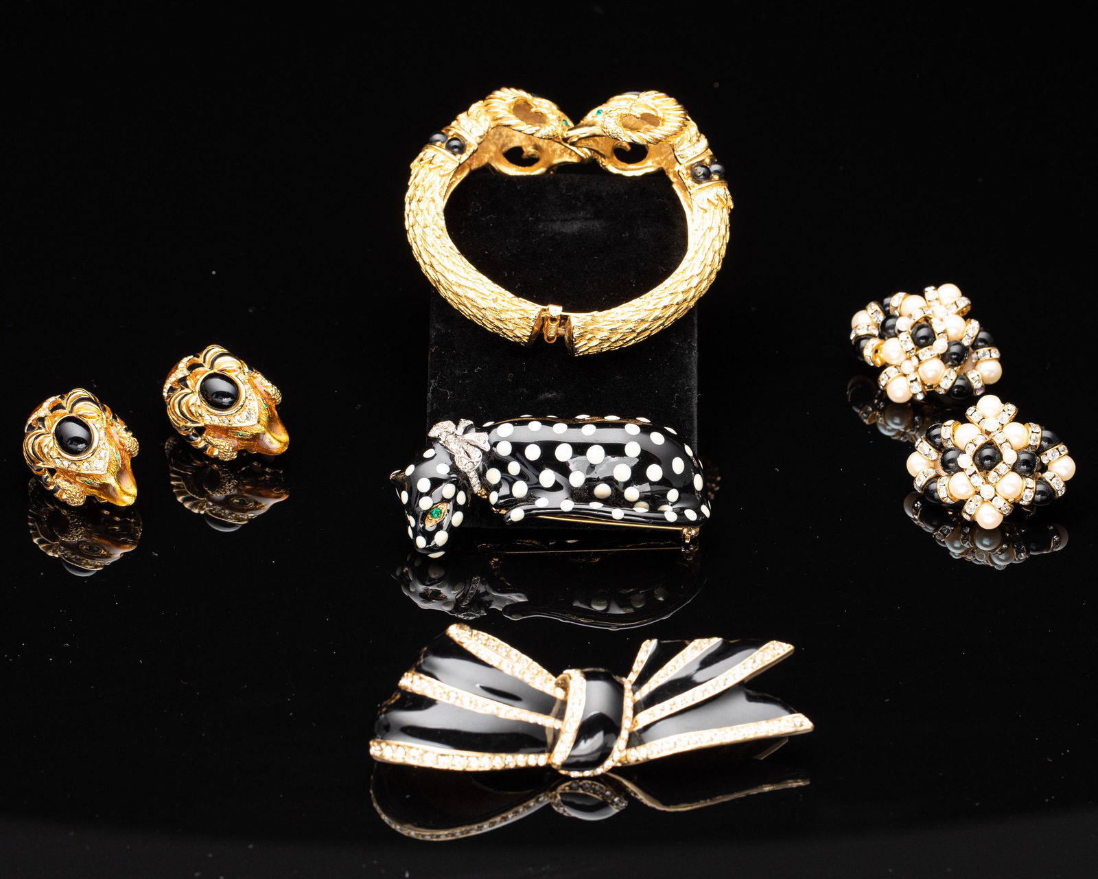 Group of Black, White, and Gold Costume Jewelry: Property from a Sea Island, GA Private Collection Description: Group of Black, White, and Gold Costume Jewelry , comprising a Ciner black enamel and crystal gold tone bow brooch (marked 'Ciner'),