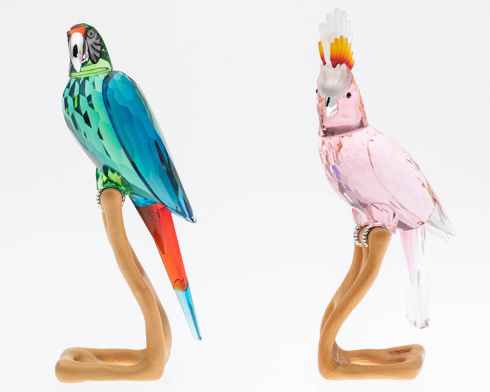 Swarovski Cockatoo and McCaw: Property from a South Carolina Estate Description: Swarovski Cockatoo and McCaw, comprising a green and red McCaw (overall 9 3/8 in. x 3 1/2 in. x 2 1/2 in.) and a pink and orange cockatoo, both o