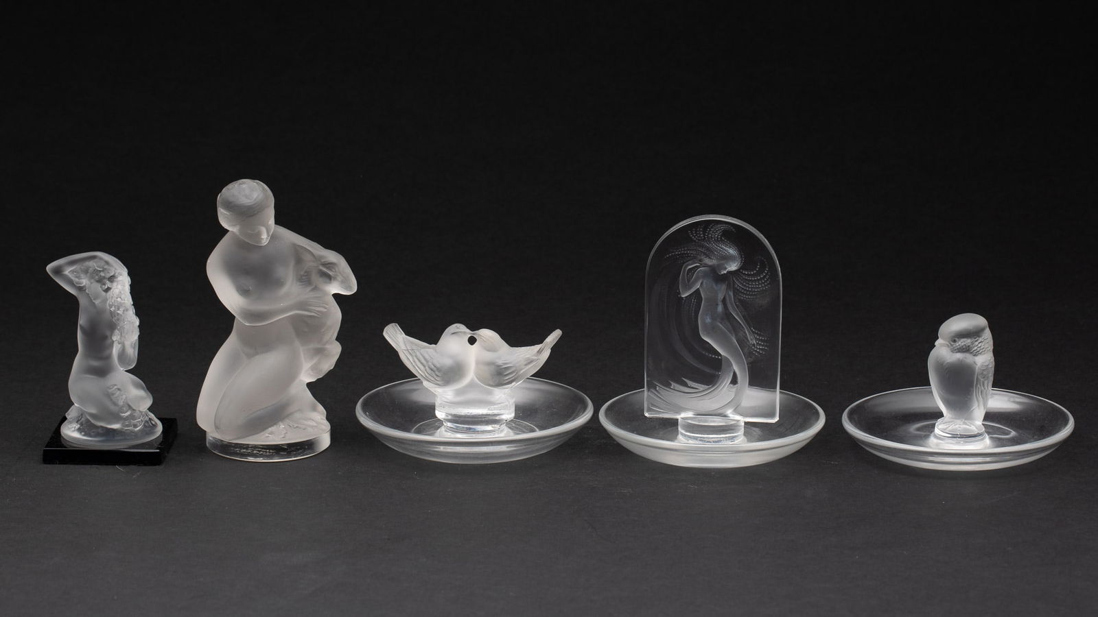 3 Lalique Glass Ring Holders and 2 Lalique Figurines: Property from an Estate, Savannah, GA Description: 3 Lalique Glass Ring Holders and 2 Lalique Figurines, comprising one ring tray with a bird, one with a female figure in an arch and another with