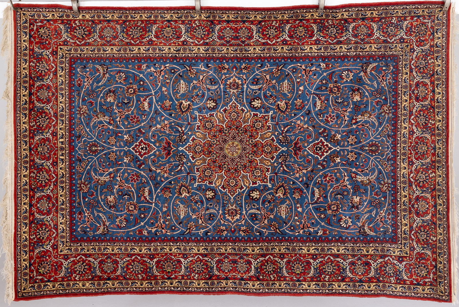 Persian Rug: Property from the Estate of a Swiss UBS Executive, Zurich and Hilton Head Island, SC Description: Persian Rug, in tones of red, cream, navy blue and deep yellow on a blue ground with red border.