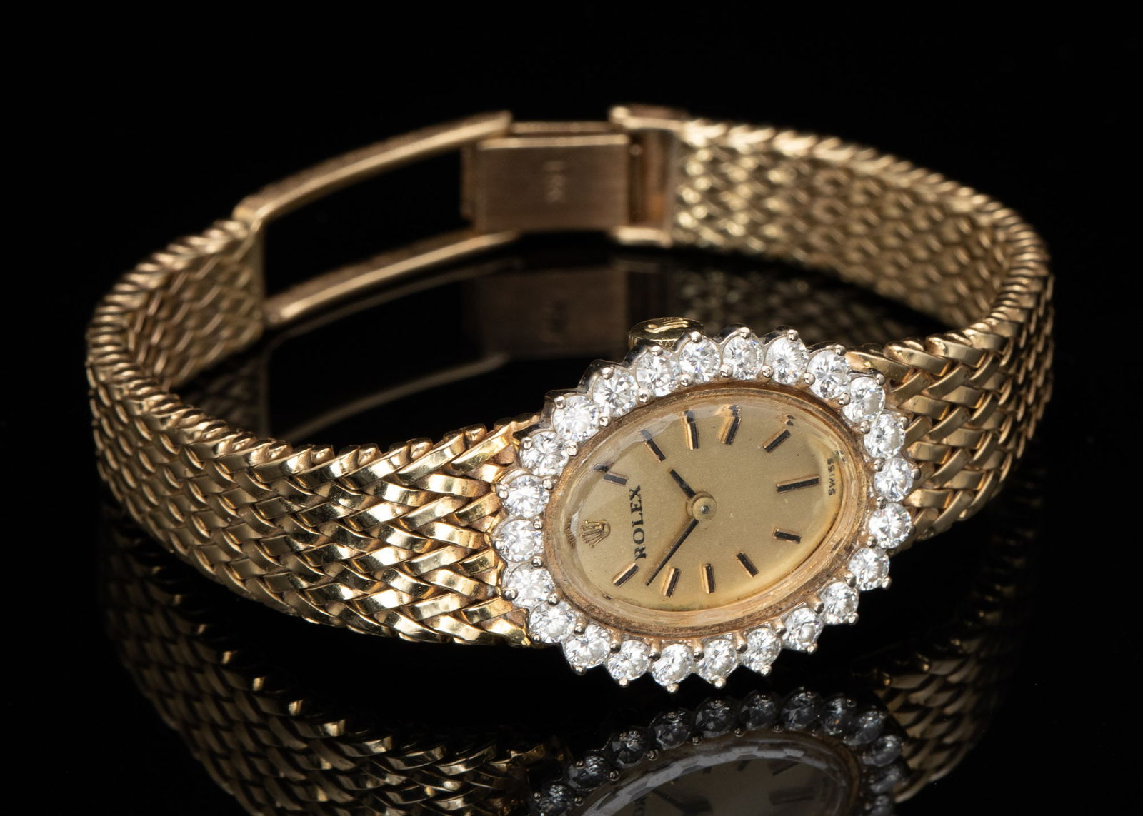 Rolex 14K Gold and Diamond Woman's Watch: Property from the Estate of Jeannie Sims, Savannah, GA and Charleston, SC Description: Rolex 14K Gold and Diamond Woman's Watch, the champagne oval dial with gold numeral marks, labeled 'Rolex, Sw