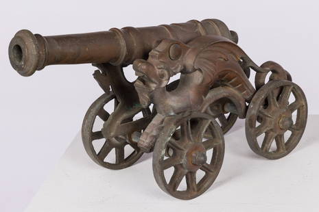 Bronze Starter Canon: Description:  Bronze Starter Canon, unmarked, with dragon form supports. Measurements: Height: 9 1/2 in. x Width: 17 1/2 in. x Depth: 7 in.