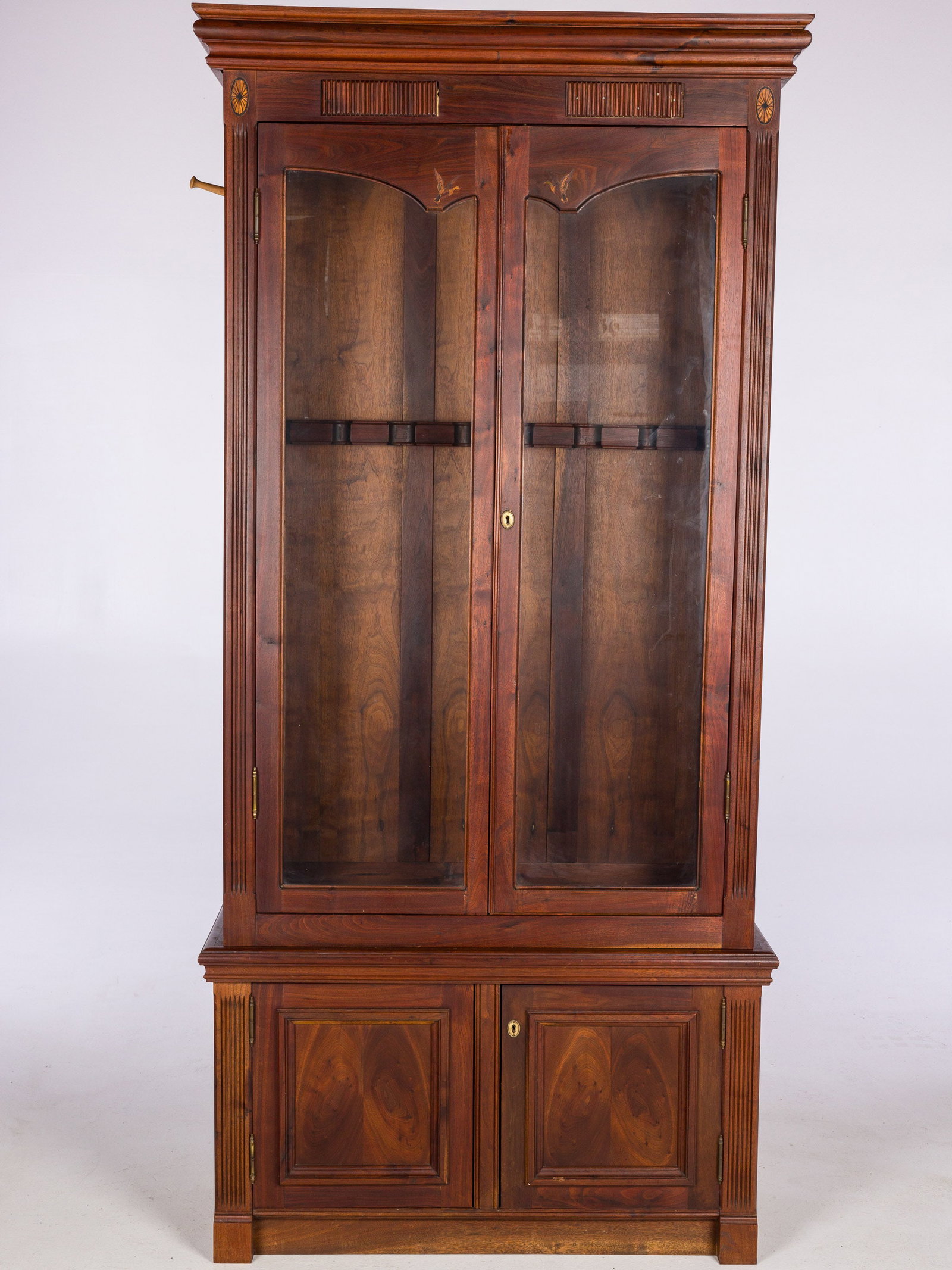 Two Part Inlaid Walnut Gun Cabinet, 20th C: Property from a Private Collection, Ponte Vedra, FL Description: Two Part Inlaid Walnut Gun Cabinet, 20th C, the upper section with glass doors opening to 7 gun racks, the lower section opening to