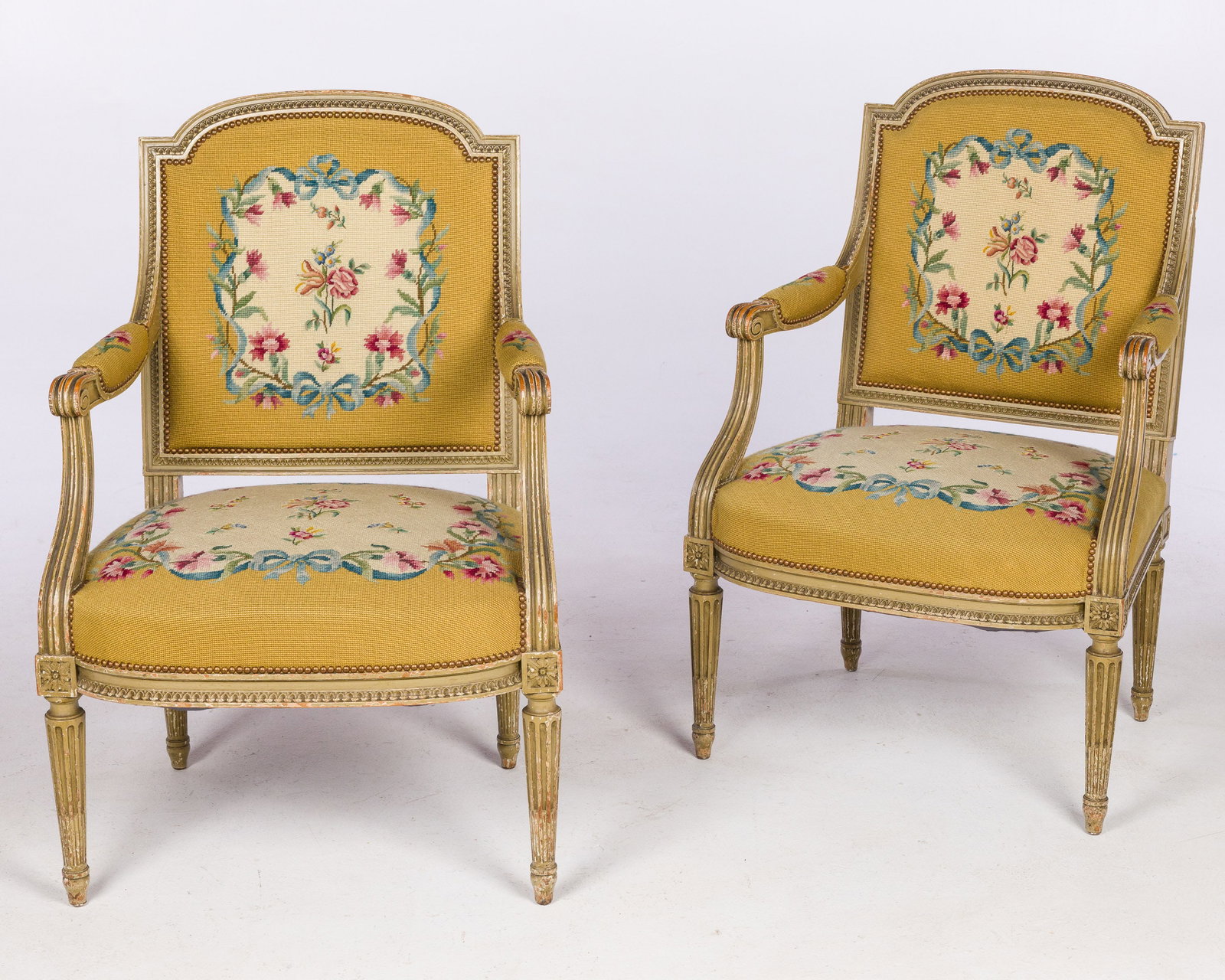 Pair Louis XVI Style Needlepoint Armchairs, 19th C: Property from a Private Collection, Beaufort, SC Description: Pair of Louis XVI Style Painted and Needlepoint Armchairs, 19th Century, with floral needlepoint upholstery with open arms centering a