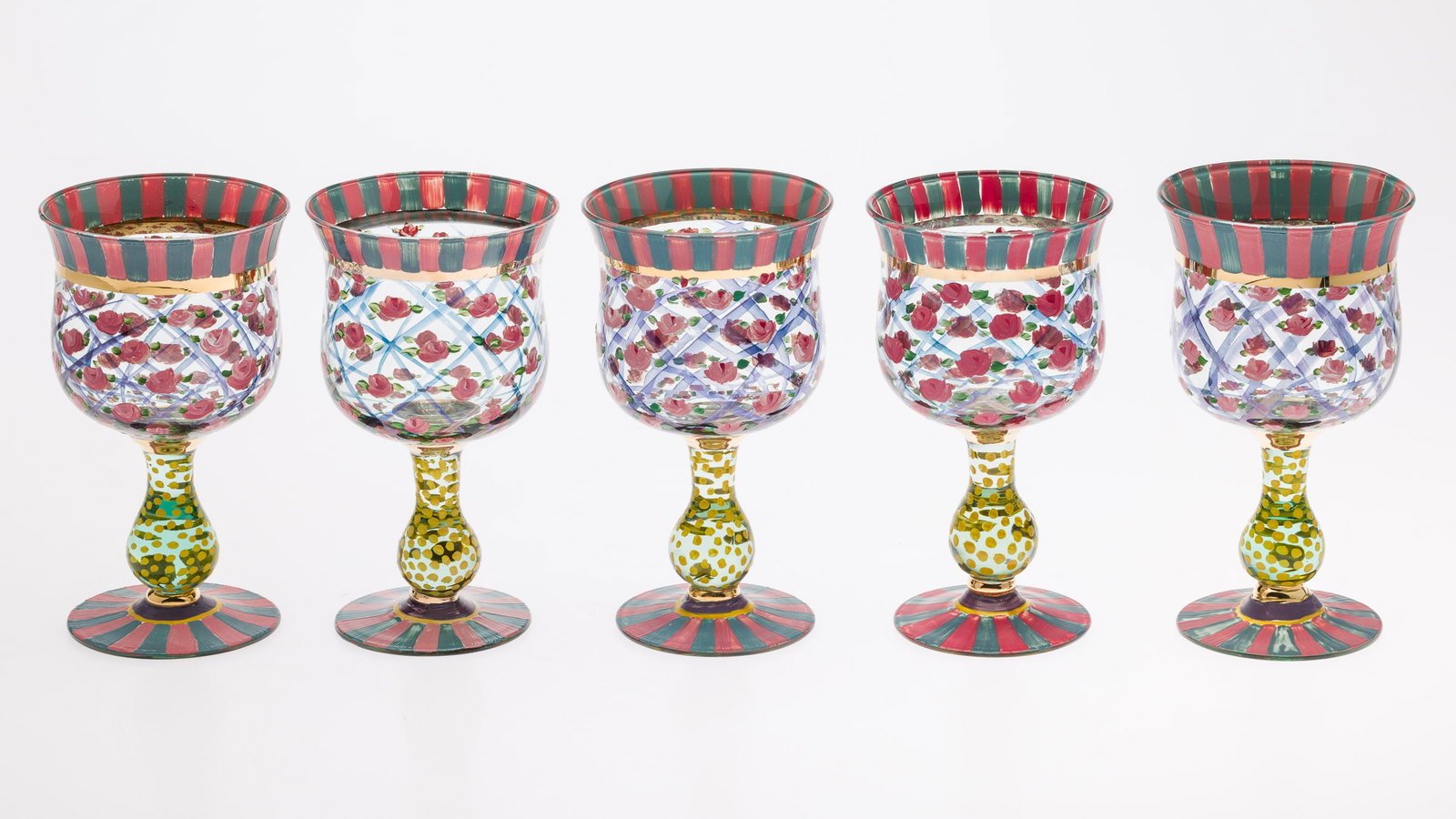 5 Mackenzie-Childs Painted Wine Glasses: Property from the Estate of Ann Lytle, Savannah, GA Description: 5 Mackenzie-Childs Painted Wine Glasses, all hand painted with pink roses, blue and pink stripes and yellow polka dot stems, marked
