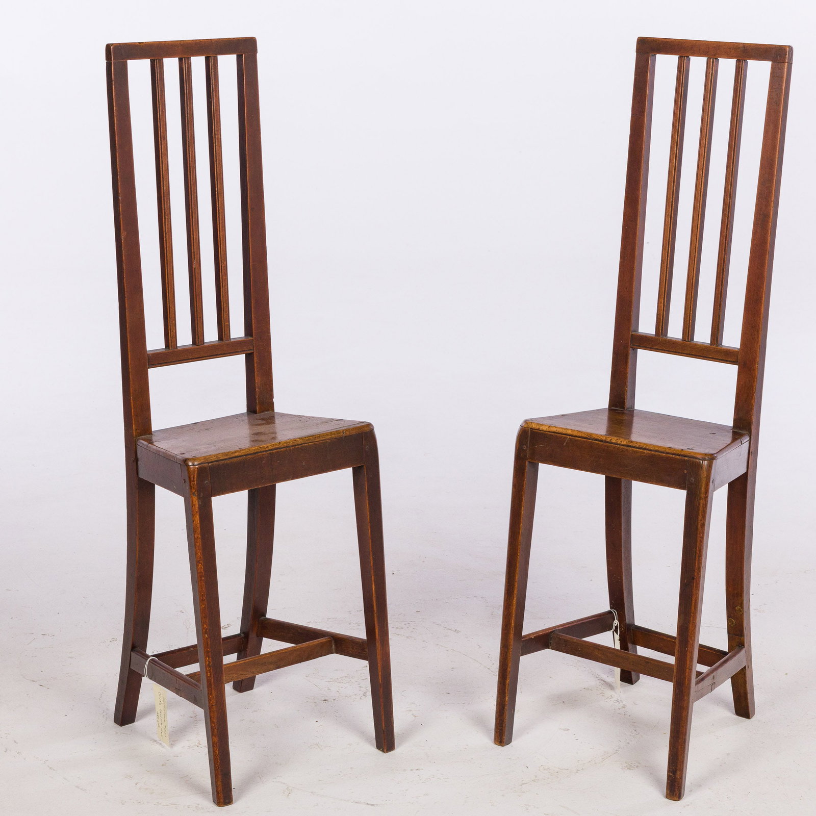 Pair of English Deportment Chairs, 19th Century: Property De-Accessioned from the Telfair Museums, Savannah, GA Description: Pair of English Deportment Chairs, 19th Century, each with tall spindle inset back and plank seat on tall legs joined by