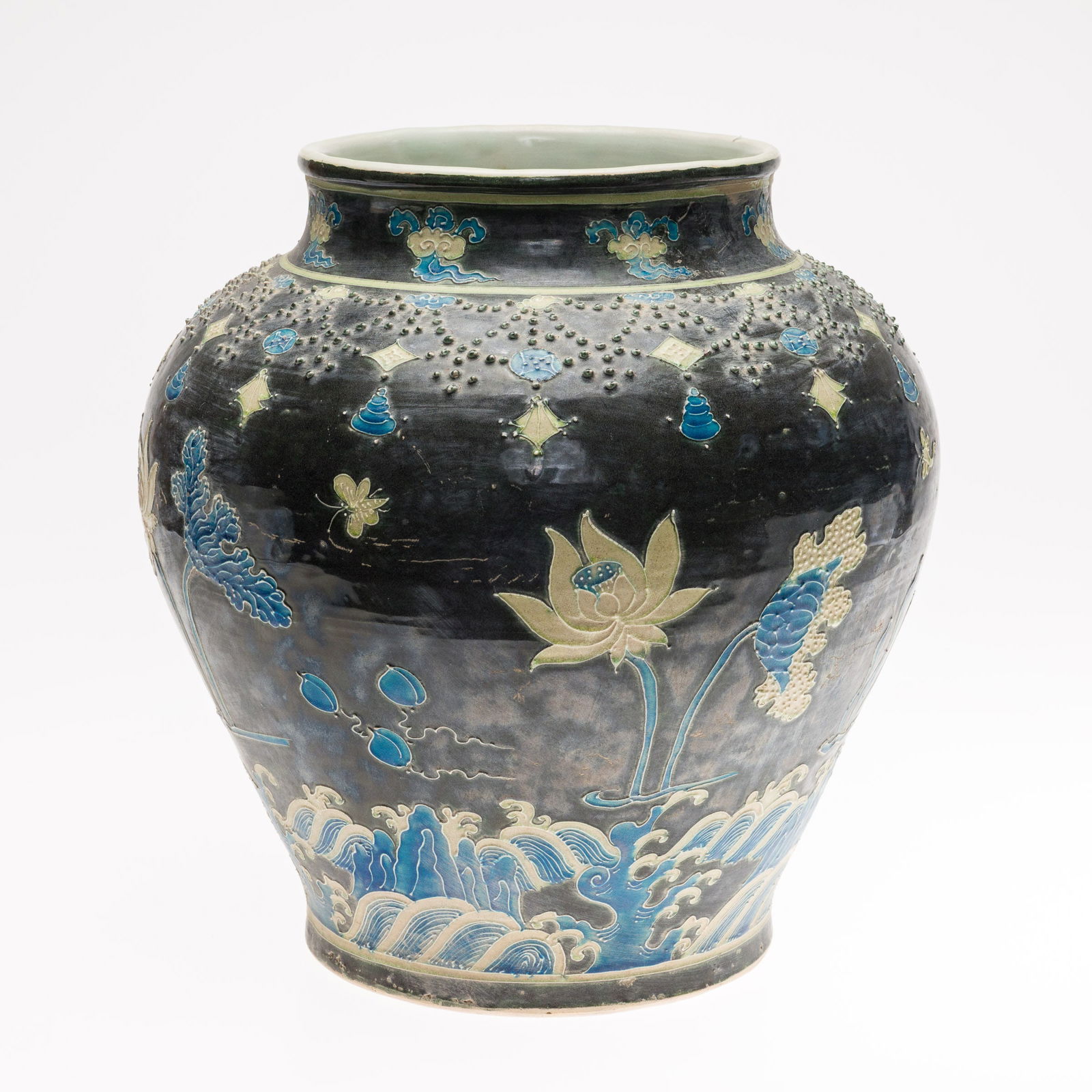 Chinese Fahua Jar: Description: Chinese Fahua Jar, decorated with lotus flowers, waves and butterflies on a dark ground, unmarked. Measurements: Height: 13 1/2 in. x Width: 12 in.