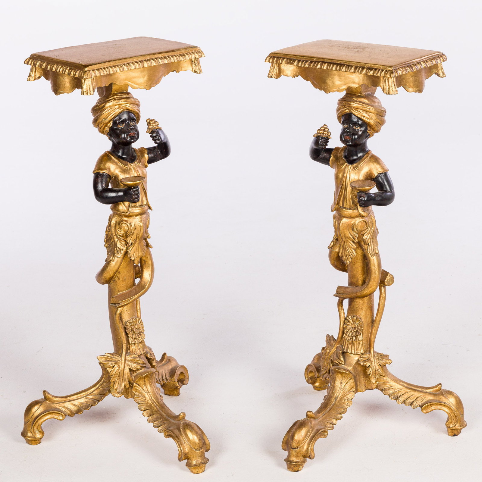 Pair of Blackamoor Pedestals: Property of Kelly Holcomb, Savannah, GA Description: , each with shaped rectangular top raised on a figural support and three downswept legs. Measurements: Height: 36 in. x Widt