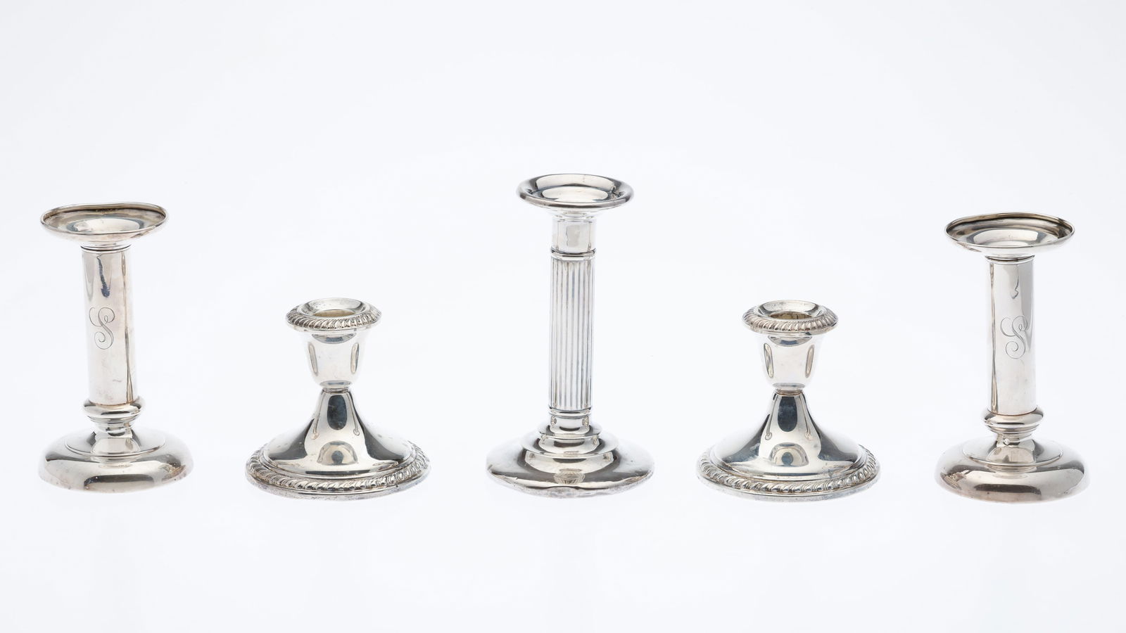 5 Sterling Silver Candlesticks: Description: 5 Sterling Silver Candlesticks, comprising a pair of Meriden Brittania Co. 5 1/4 in. candlesticks with 'S' monogram (marked 'Sterling 342'), a singular 6 1/4 in. columnar candlestick