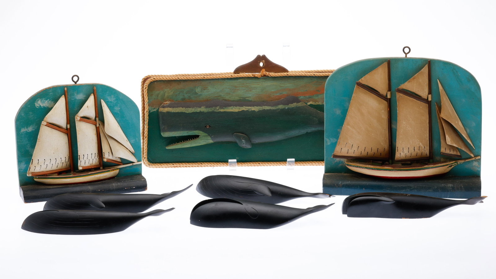 5 Carved Wood Whales and Three Wall Plaques: Description: 5 Carved Wood Whales and Three Wall Plaques, comprising 5 carved and painted wood whales, each with pencil label on verso; together with two carved and painted wood sailboat wall pla