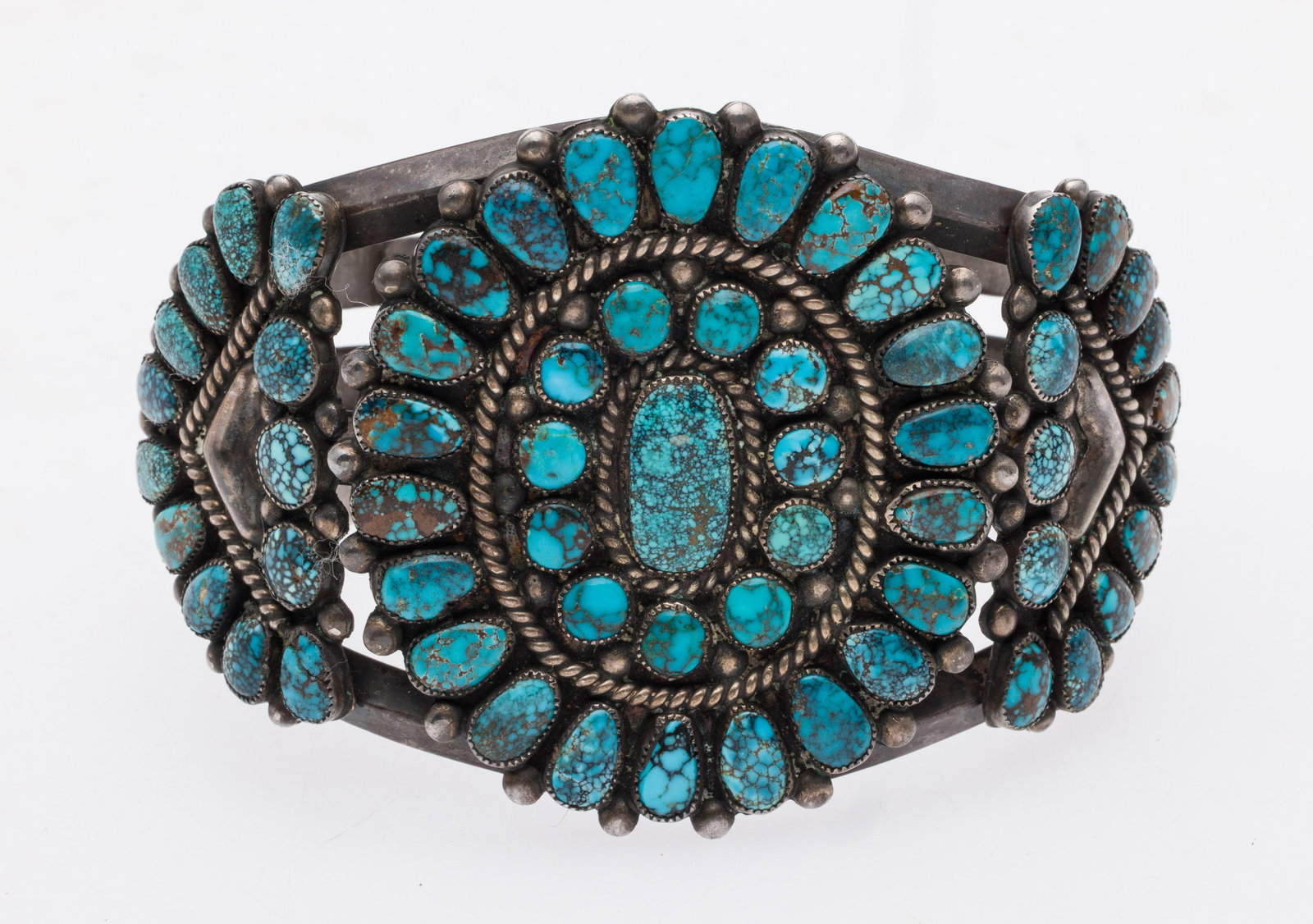 Native American Silver & Turquoise Cuff Bracelet: Description: Native American Silver and Turquoise Unmarked Cuff Bracelet, with oval and circular turquoise cabochons in a flower motif, unmarked. Measurements: Width: 2 5/8 in.