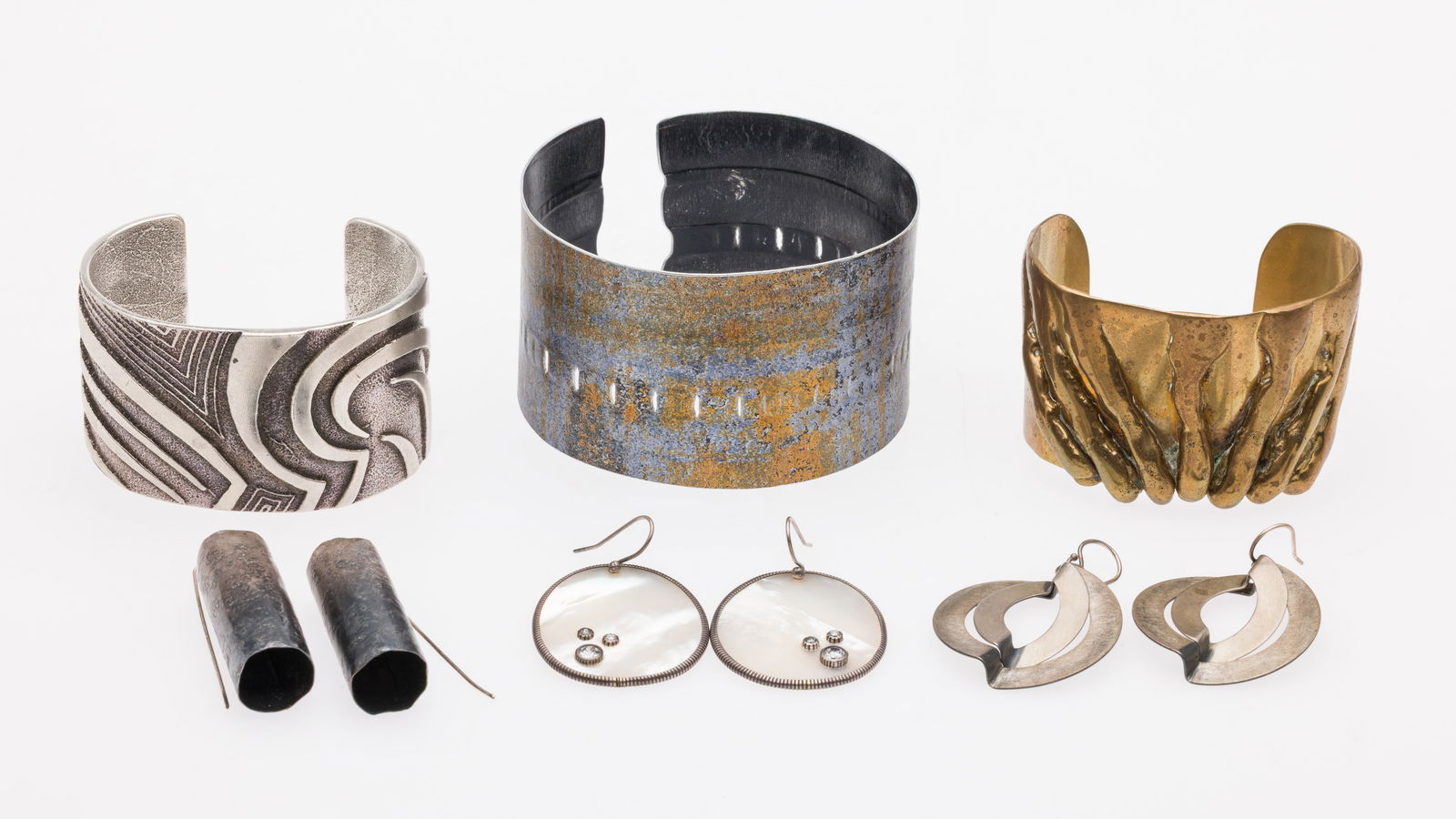 Three Cuffs & 2 Pairs of Earrings, Inc. Stephen Burr: Description: Three Modern Cuffs and 2 Pairs of Earrings, Inc. Stephen Burr, comprising a gold tone cuff signed Stephen Burr; unsigned silver and gold tone cuff with wrapped pierced design; a silv
