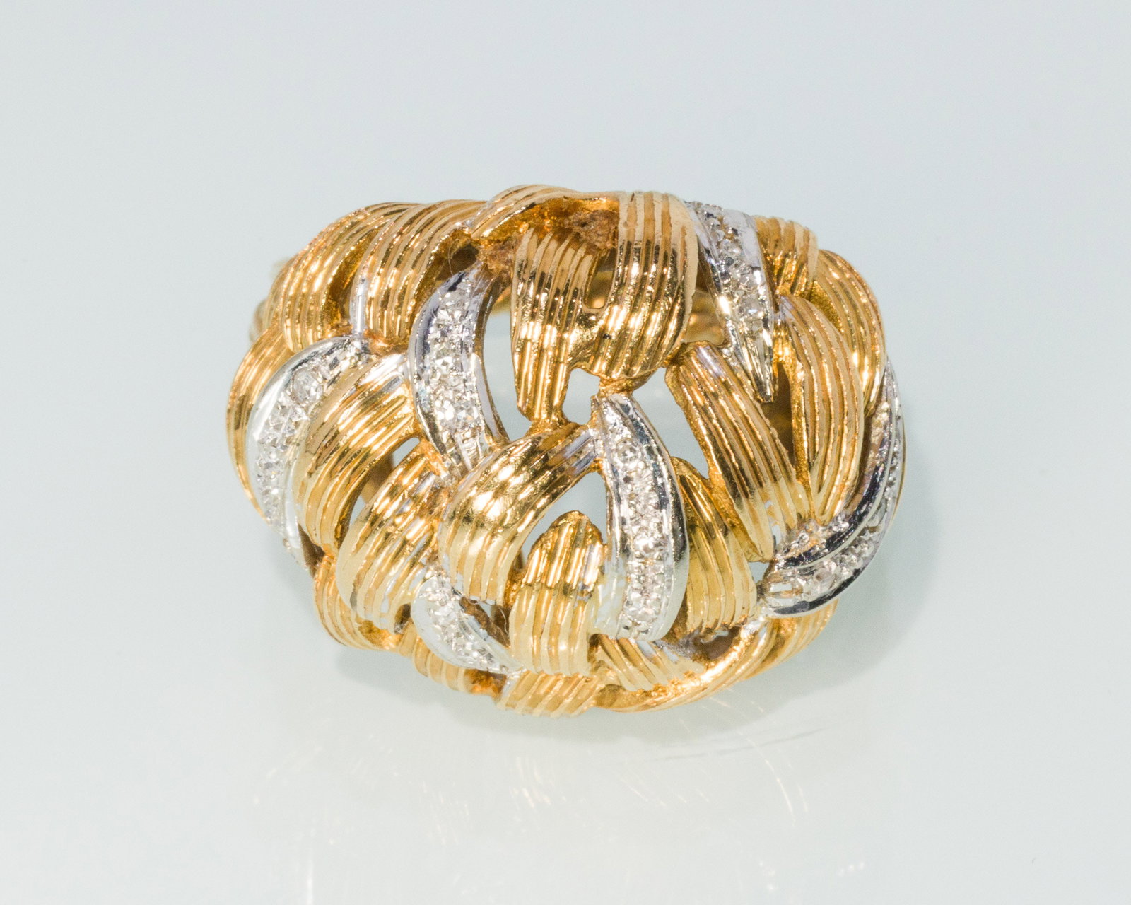 18K Gold and Diamond Ribbon Cocktail Ring, Size 6.5: Description: 18K Gold and Diamond Ribbon Cocktail Ring, Size 6.5, 18K yellow and white gold braided ribbon ring featuring pave set diamonds, the band marked '750'. 13.23 grams overall.