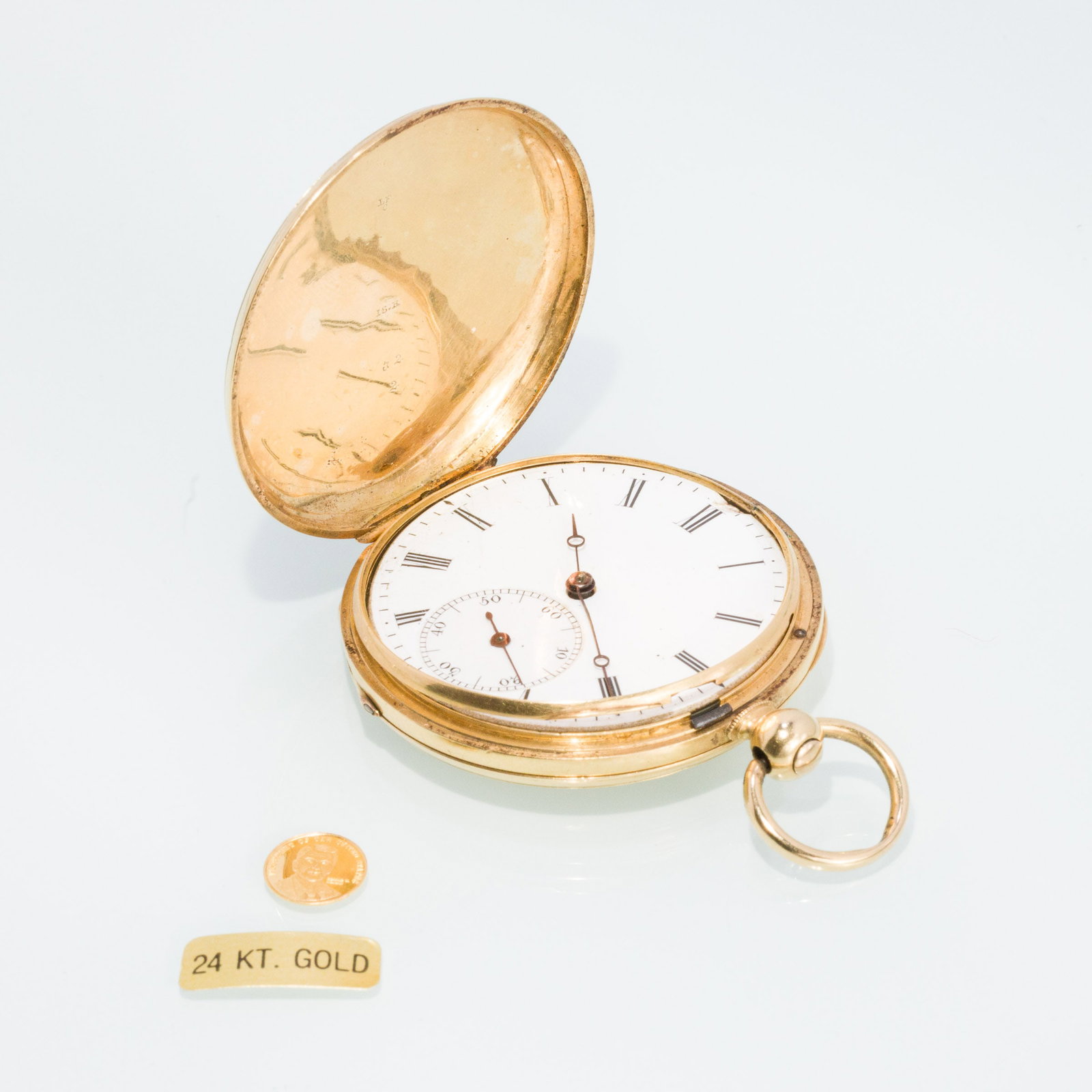 18K Pocket Watch & 24K Commemorative R. Reagan Coin: Description: Gentleman's 18K Pocket Watch & 24K Commemorative R. Reagan Coin, a 18K yellow gold pocket watch, the case marked '18K, 32' and '10432', the case over works inscribed 'No. 10432, Cyli