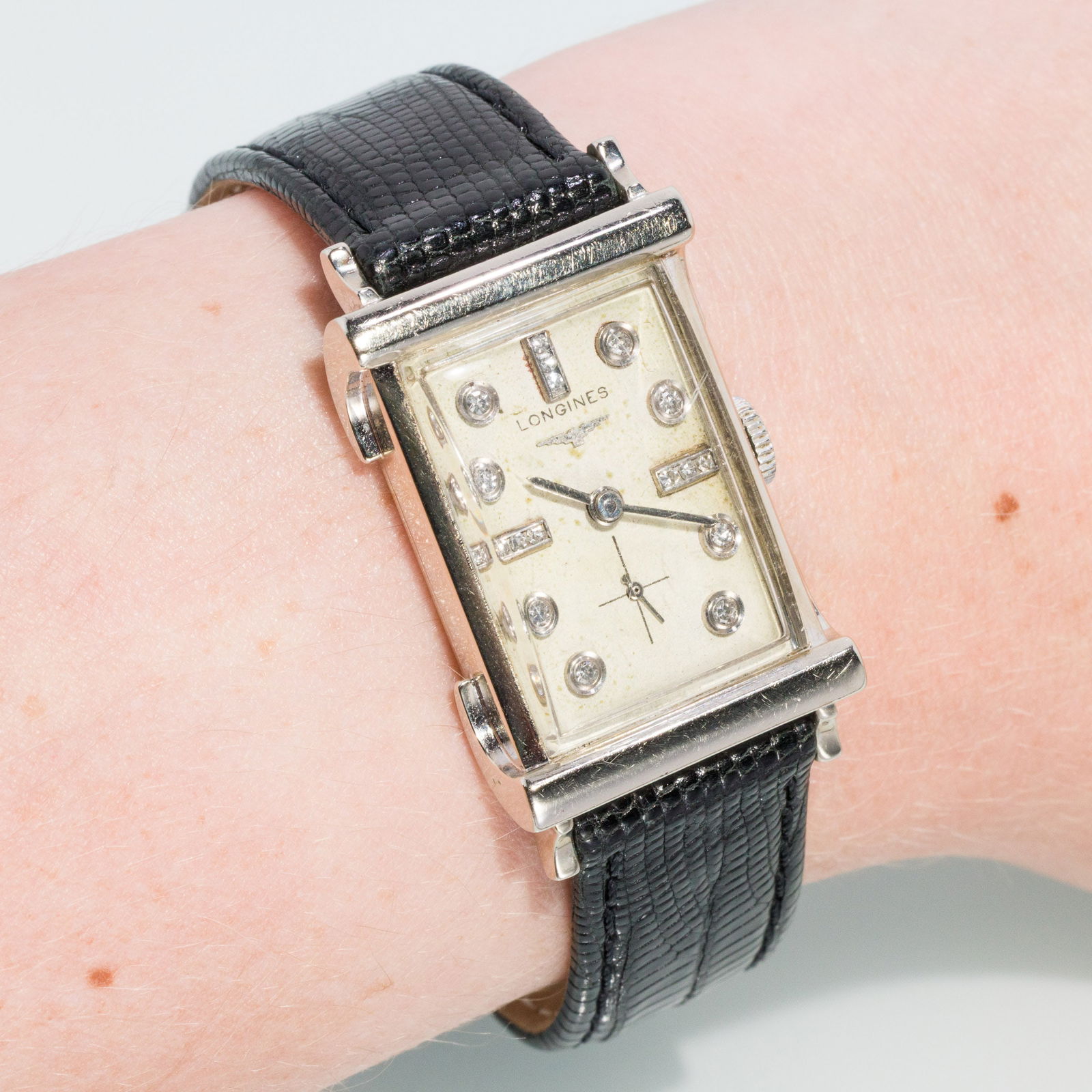 Longines 14K Gold Watch: Description: Longines 14K Gold Watch, a rectangular 14K white gold case with white dial and diamond hour markers, on a black leather band, marked 'K&E, 14K' and monogramed and inscribed 'JD, June