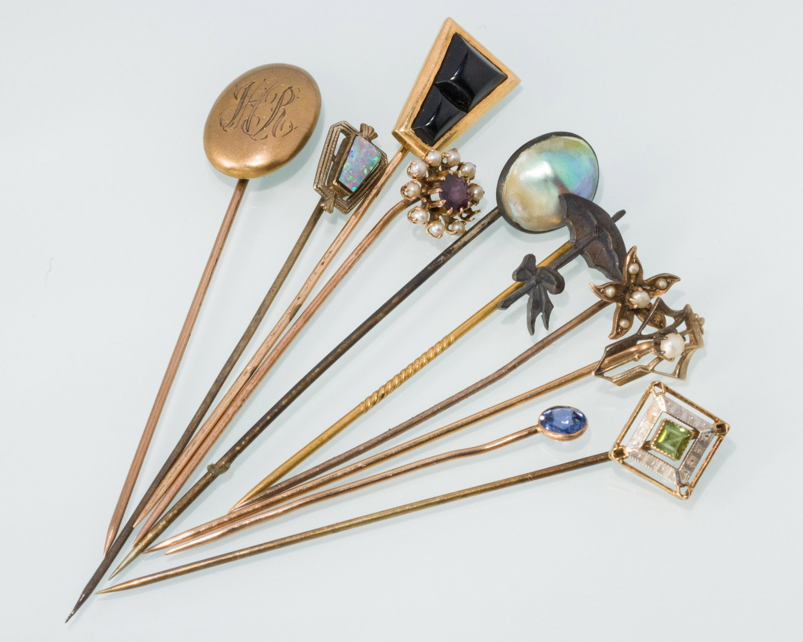 Group of 10 Gold Stick Pins: Property from a Private Collection, Jacksonville, FL Description: Group of 10 Gold Stick Pins, comprising an onyx pin (unmarked); a 14K and opal pin (marked '14K'), a 10K oval pin with monogram (m