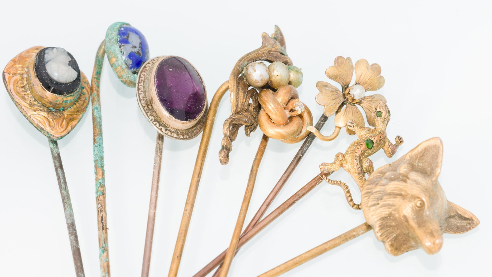 Group of 8 Gold Stick Pins: Property from a Private Collection, Jacksonville, FL Description: Group of 8 Gold Stick Pins, comprising a fox head pin (unmarked), a cameo pin (unmarked, oxidized), a foliate and pearl pin (unmar