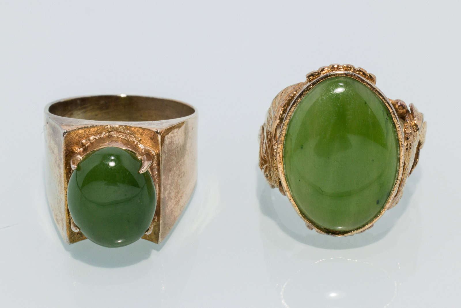 Two Jade Rings: Property from a Private Collection, Jacksonville, FL Description: Two Jade Rings, a wide yellow gold band with oval jade cabochon, size 6.5, and a decorative yellow gold band set with oval jade ca