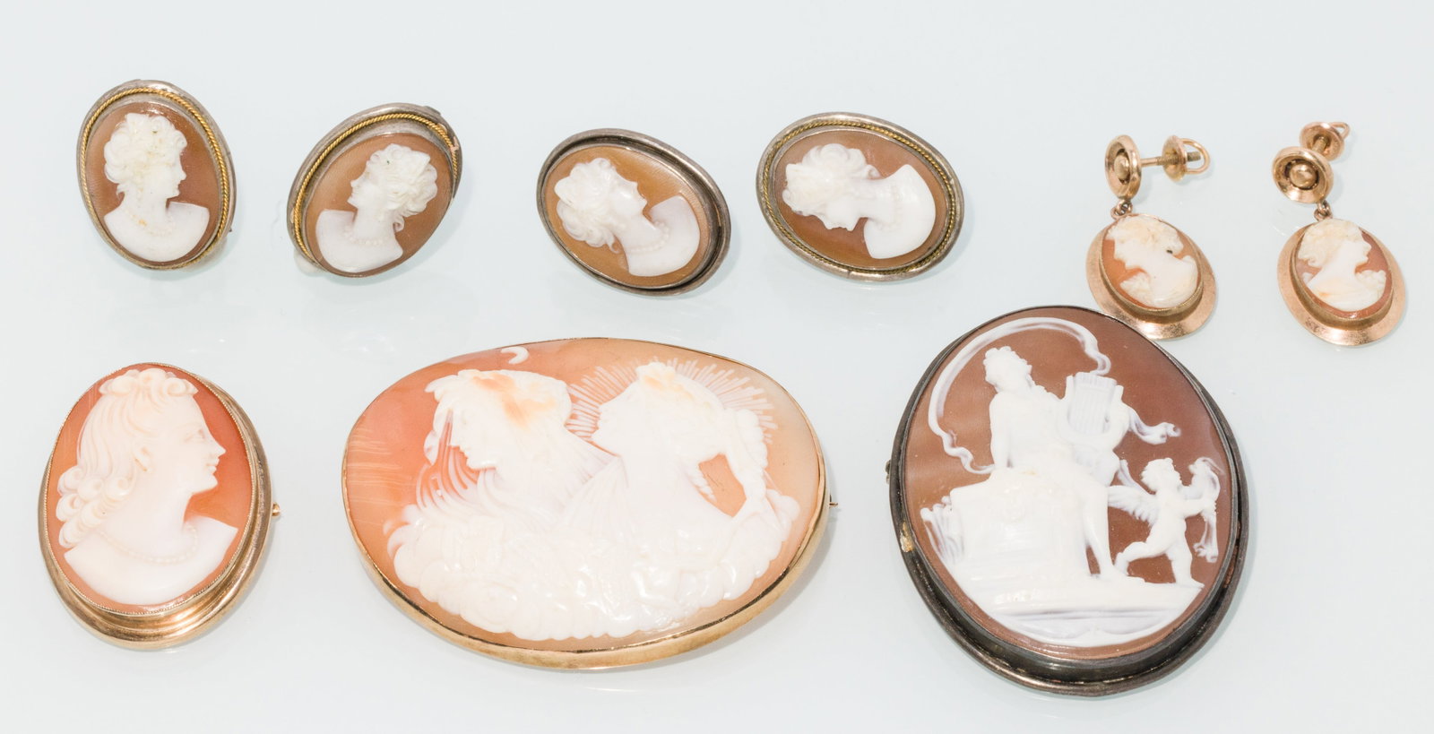Three Cameo Brooches and Three Sets of Earrings: Description: Three Cameo Brooches and Three Sets of Earrings, comprising a cameo pin with 14K gold surround, a cameo pin with 800 silver surround, a cameo pin with 10K surround, a pair of cameo p