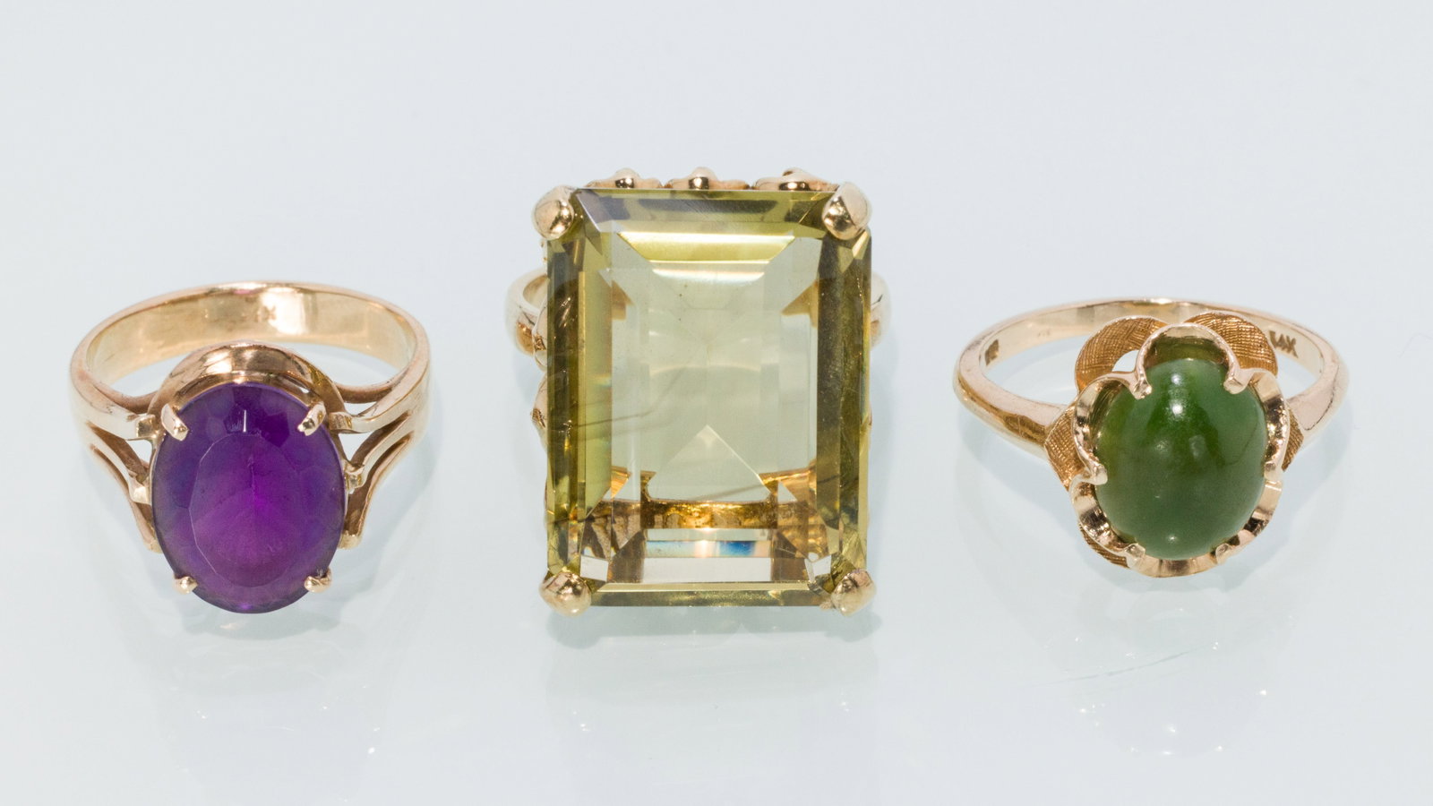 Three Gemstone Rings with Jade, Citrine, & Amethyst: Description: Trio of Gemstone Rings with Jade, Citrine, and Amethyst, comprising a 14K yellow gold ring featuring a large rectangular green citrine (approx. 19.7 mm x 14.7 mm), size 6.35 (marked
