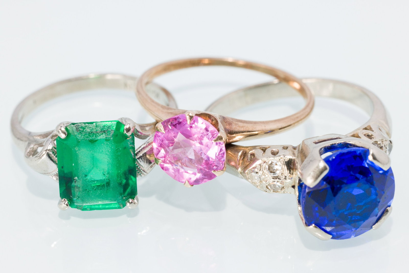 A Trio of Ladies Gemstone Rings: Property from a Private Collection, Jacksonville, FL Description: A Trio of Ladies Gemstone Rings, featuring a synthetic sapphire with three small round diamonds on either side, in 14K white gold
