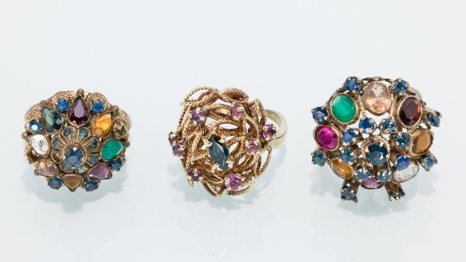 Trio of Ladies Pinwheel Style Rings: Property from a Private Collection, Jacksonville, FL Description: Trio of Ladies Pinwheel Style Rings, including a 14K yellow gold gemstone ring featuring 8 round rubies and center marque sapphire