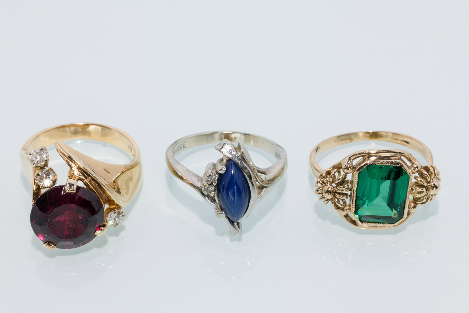 Trio of Ladies Gemstone Rings: Property from a Private Collection, Jacksonville, FL Description: Trio of Ladies Gemstone Rings, a 14K yellow gold ring featuring a round faceted garnet, accented by three diamonds, hallmarked N.P