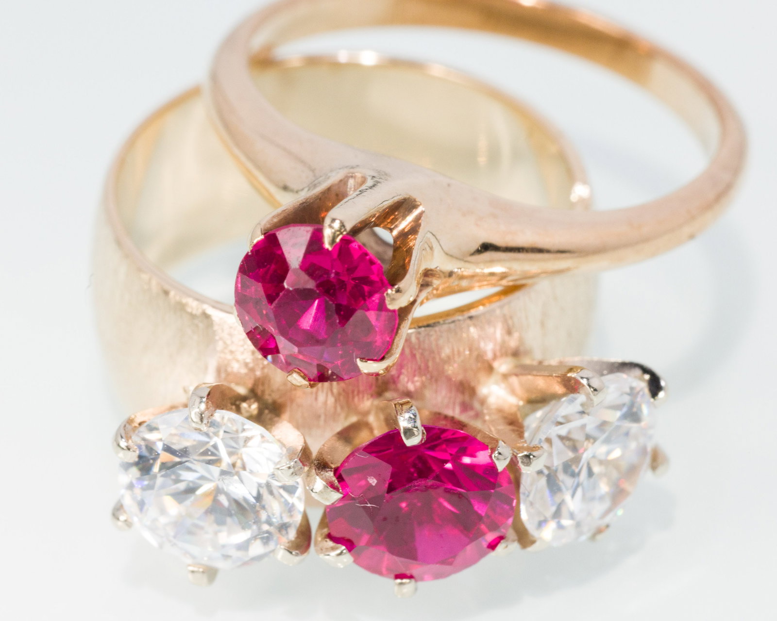 Two Ladies Synthetic Ruby and Diamond Rings: Property from a Private Collection, Jacksonville, FL Description: Two Ladies Synthetic Ruby and Diamond Rings, both in 14K yellow gold, one featuring two round faceted cubic zirconia and a round f