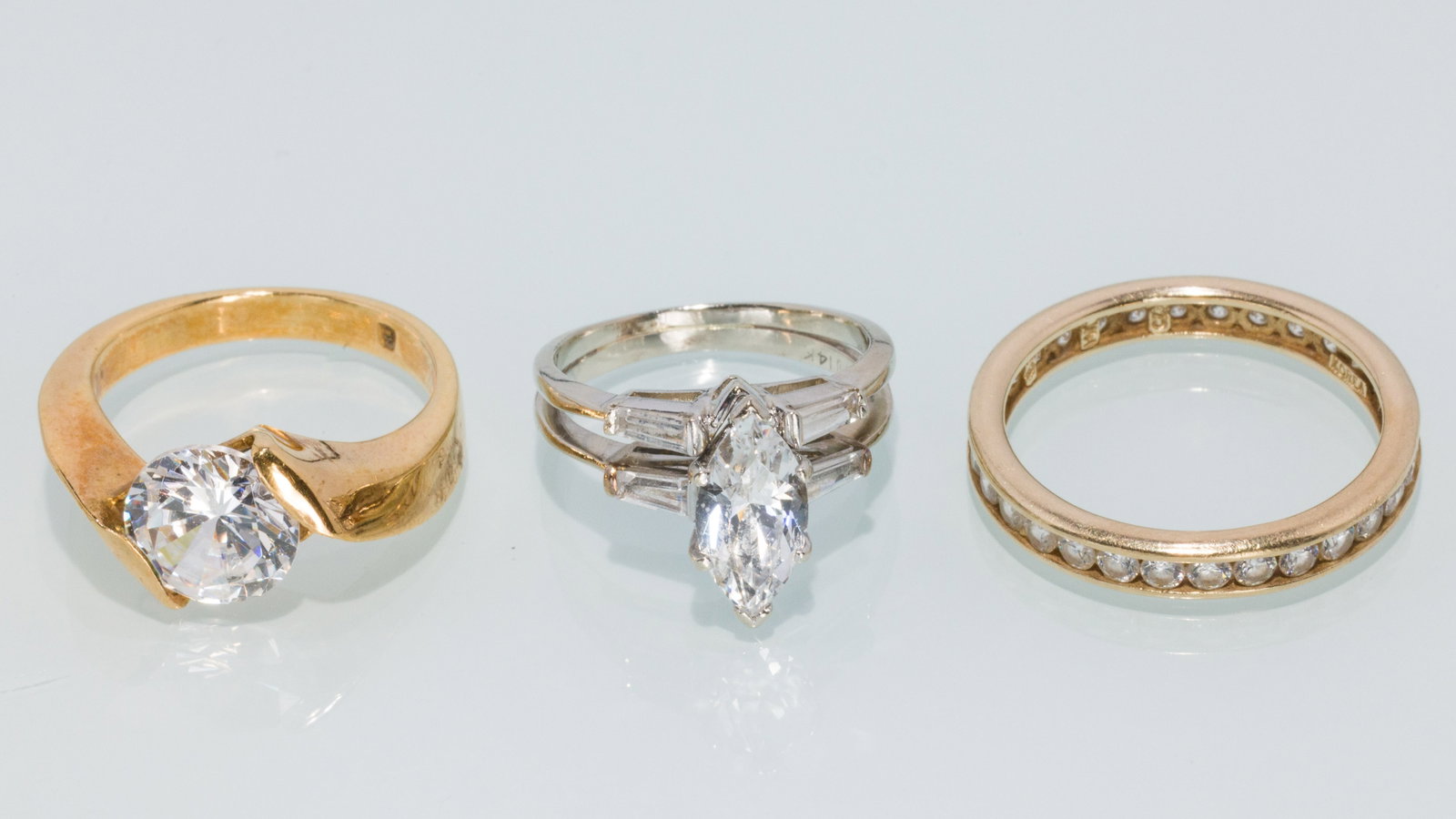 Trio of Synthetic and Gold Ladies Rings: Property from a Private Collection, Jacksonville, FL Description: Trio of Synthetic and Gold Ladies Rings, comprising a 14K yellow gold channel set cubic zirconia eternity band hallmarked and mark